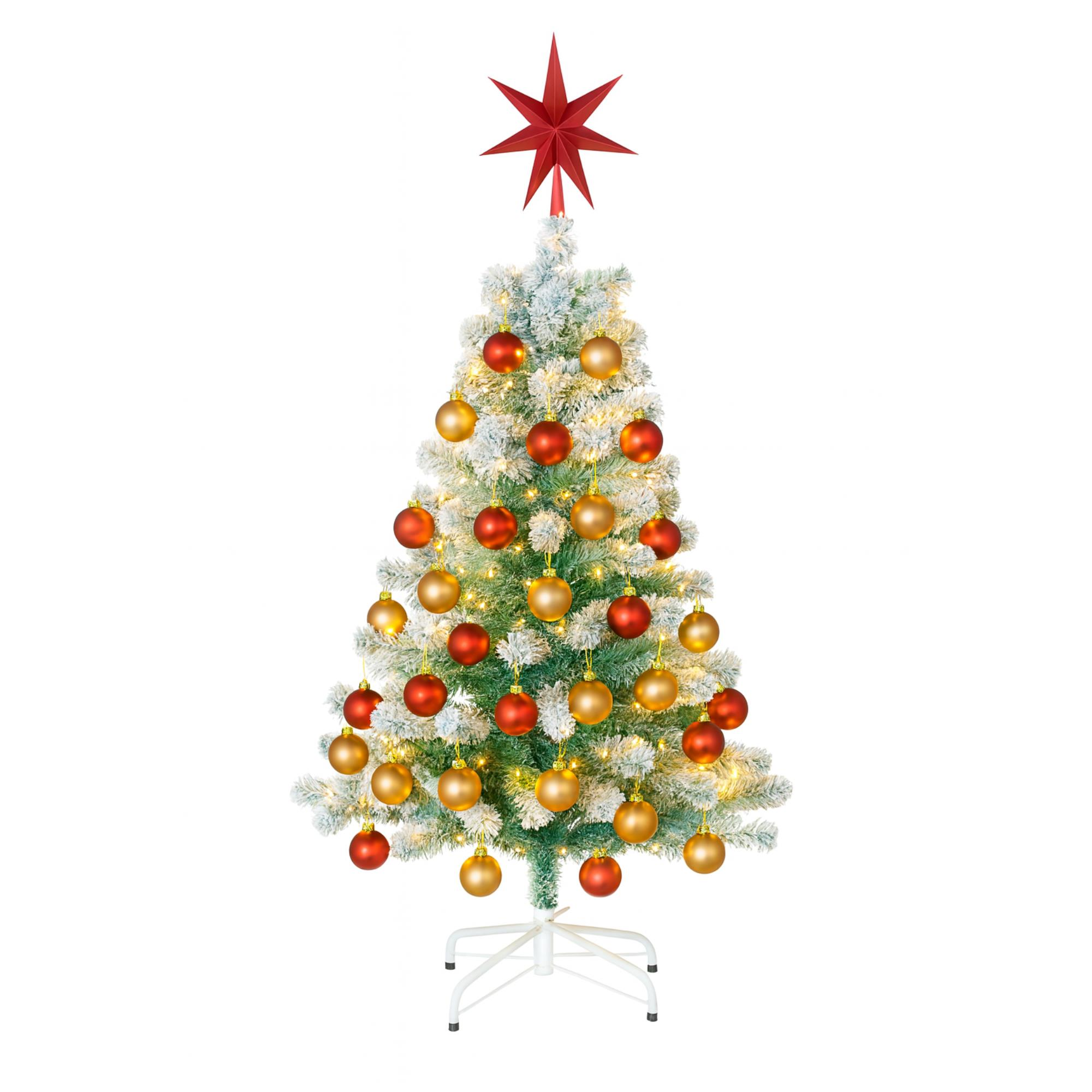 Un árbol de Navidad decorado sobre un soporte blanco. Tiene adornos rojos y dorados y una estrella roja encima.