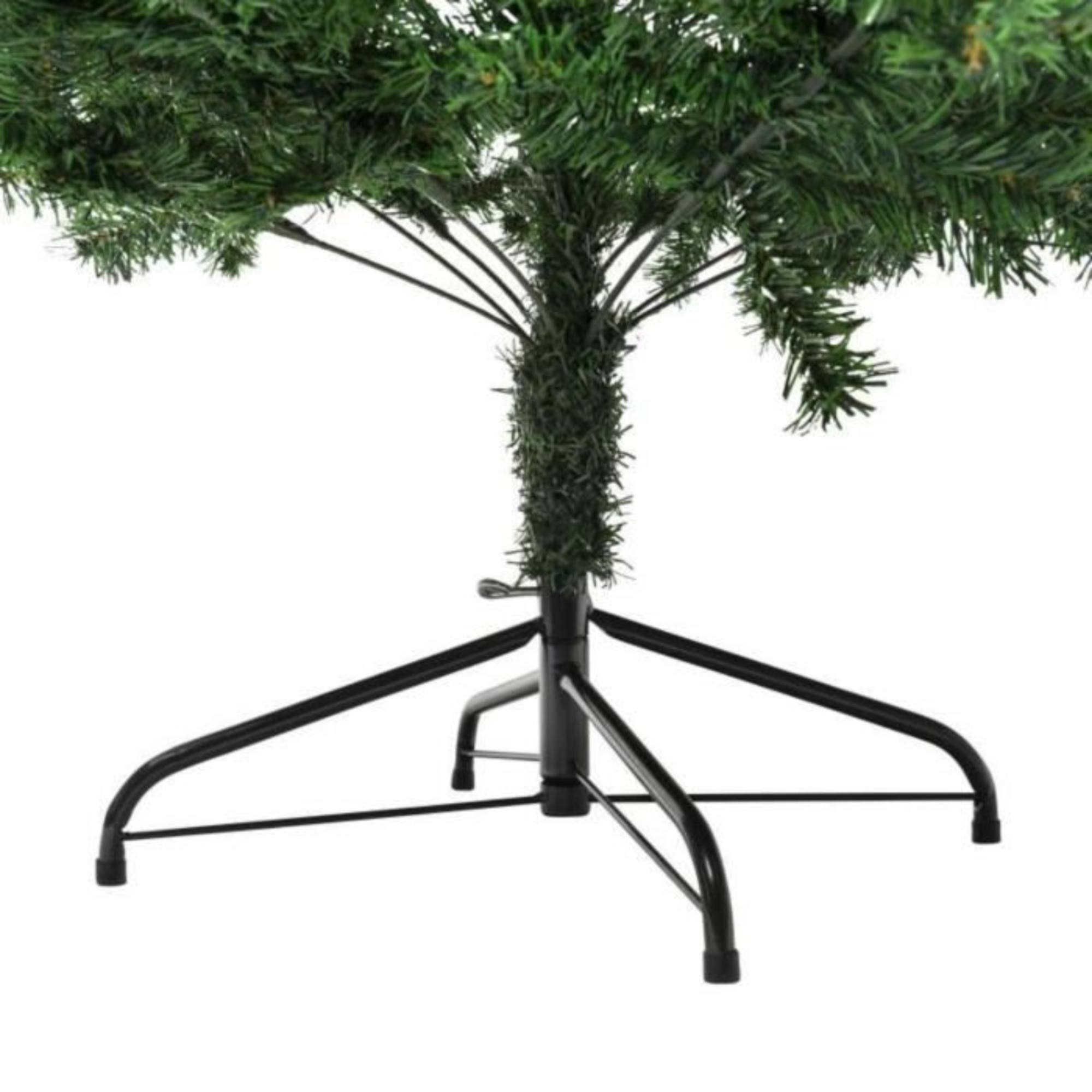 Base verde de un árbol de Navidad artificial. Soporte de metal negro sostiene el árbol. Fondo blanco.