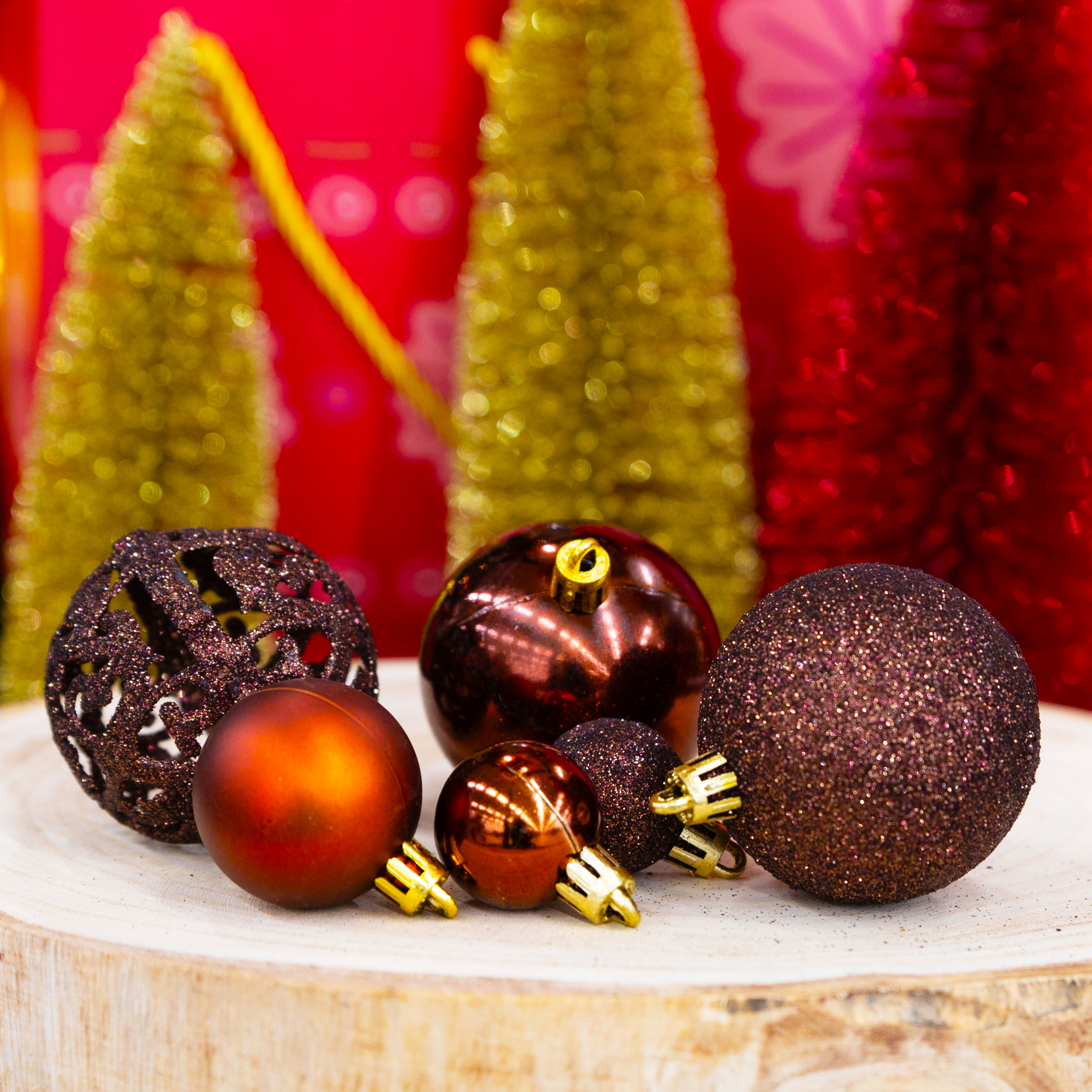 Ornements de Noël sur bois. Boules marron et rouge avec des accents dorés et des arbres dorés en arrière-plan flou.