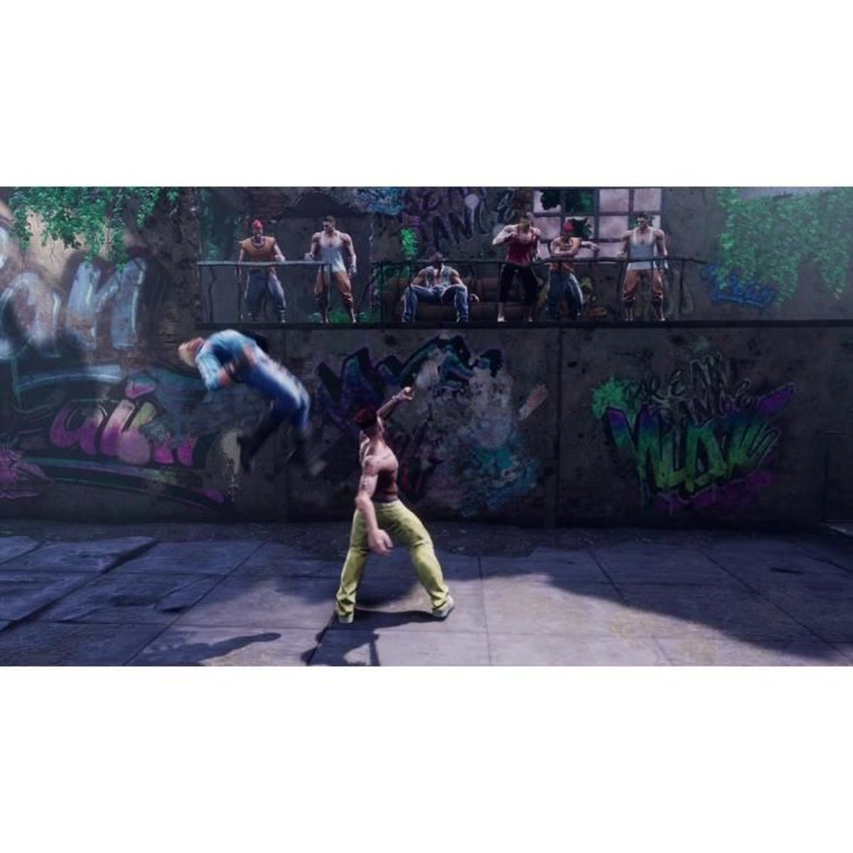 Mężczyzna w żółtych spodniach walczy, inny jest rzucany. Graffiti na ścianie, mężczyźni patrzą.