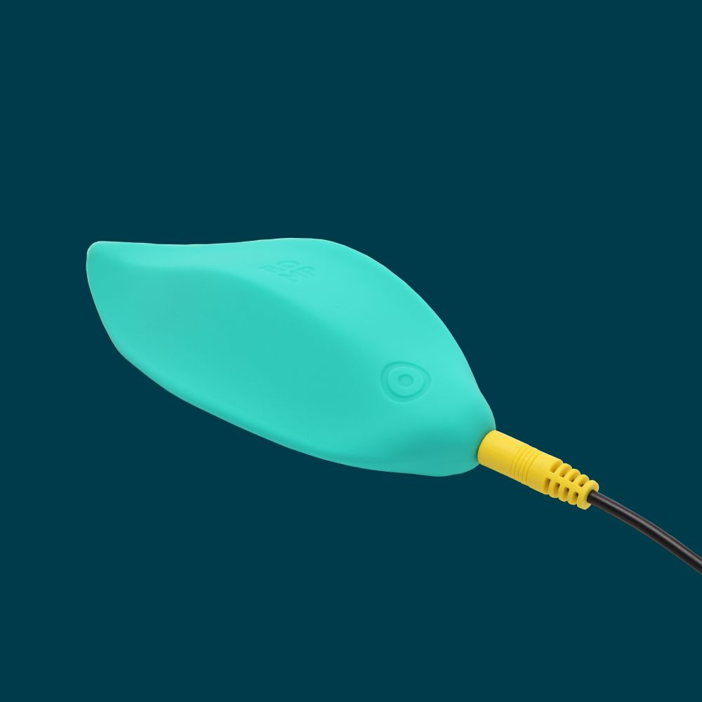 Un objeto turquesa en forma de hoja con un cable amarillo y negro que se extiende desde él, sobre un fondo turquesa oscuro.