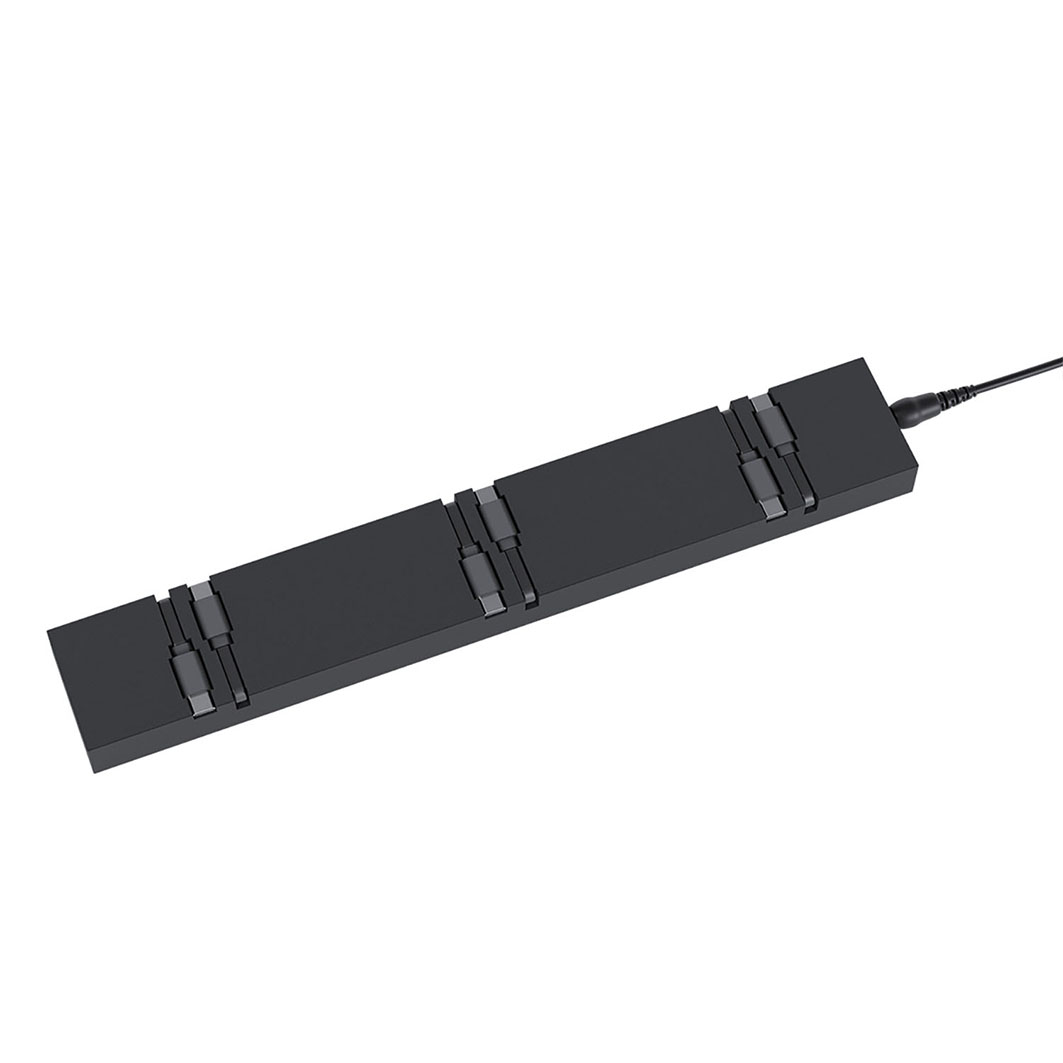 Eine schwarze, rechteckige Ladestation mit mehreren Ladeschlitzen und einem schwarzen Kabel, das sich von einem Ende erstreckt, vor weißem Hintergrund.