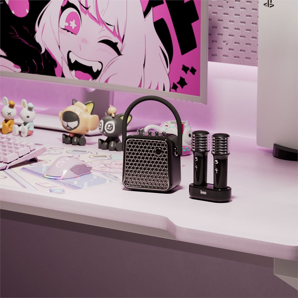Anime sanatı gösteren bir monitörle bir masa düzeni. Bir hoparlör, mikrofonlar, oyuncaklar ve bir fare görülebilir. Sahne pembe tonlardadır.