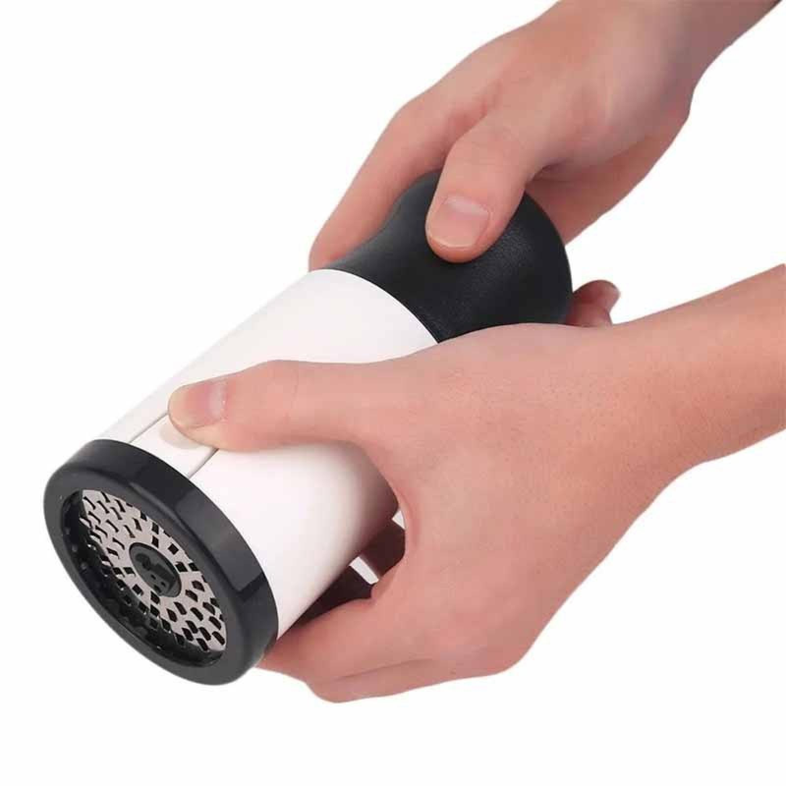 Hände halten einen weiß-schwarzen Pfeffermühle. Eine Hand hält den Körper, die andere die Oberseite.