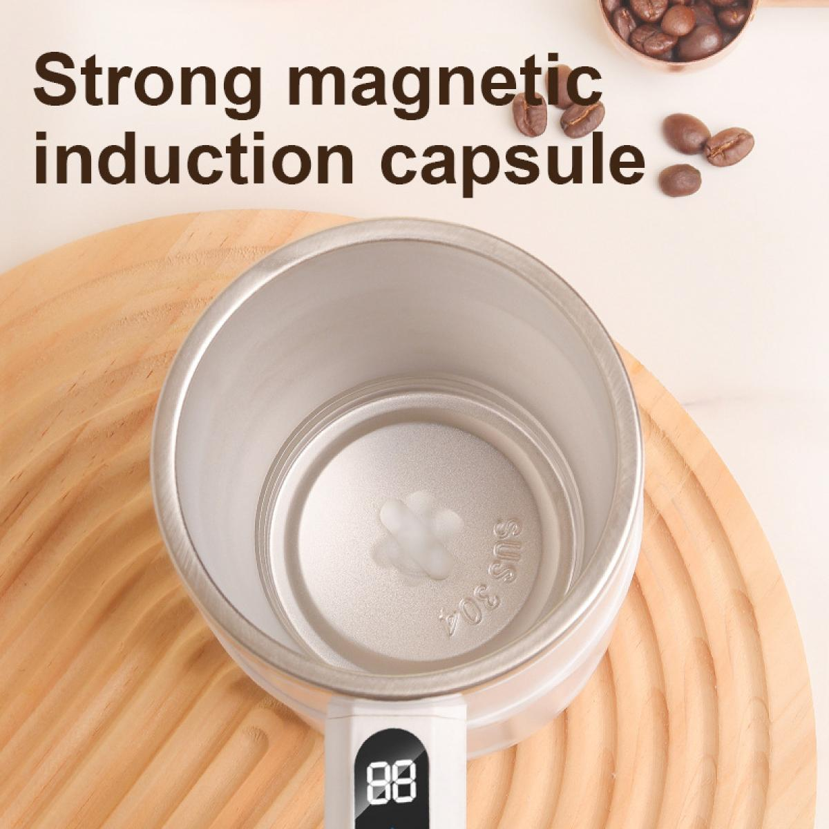 Ein Metallbecher steht auf einer Holzoberfläche. Kaffeebohnen und der Text 'Strong magnetic induction capsule' sind sichtbar.