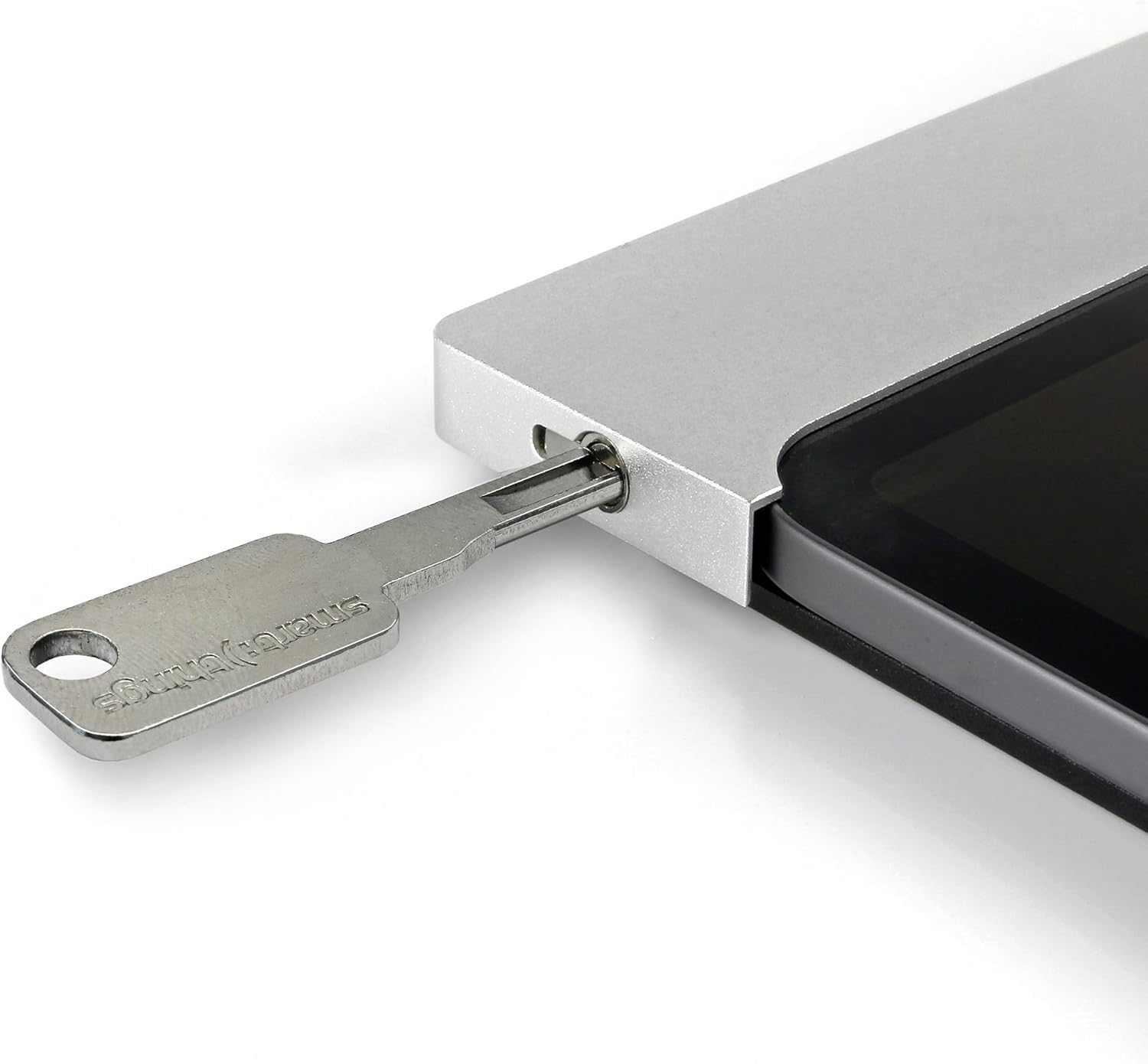 Ein Metallschlüssel mit der Aufschrift 'smart things' wird in ein silbernes, rechteckiges Gerät gesteckt. Rechts ist ein schwarzer Bildschirm zu sehen.