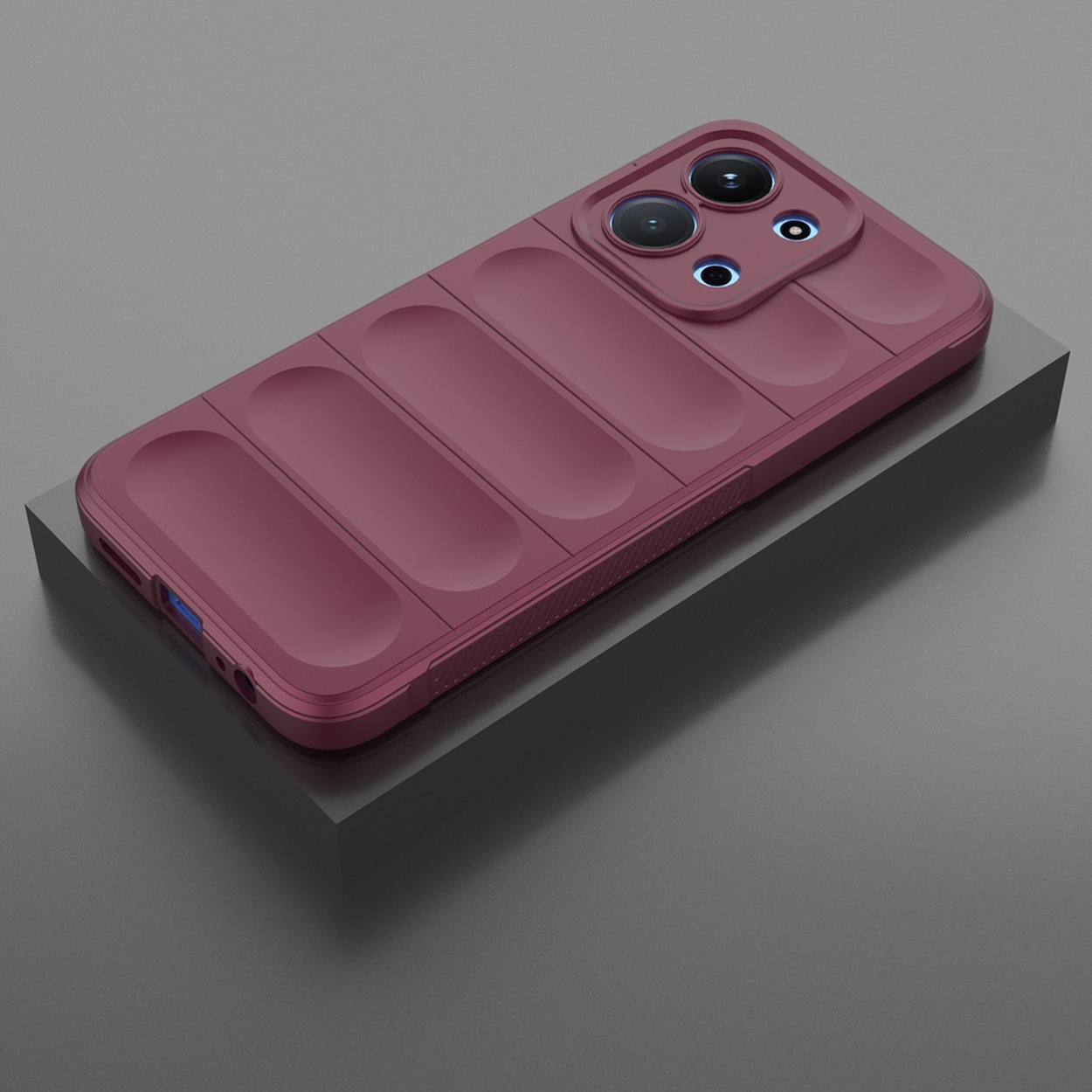 Een bordeauxrode telefoonhoes met camerabobbels ligt op een donkergrijze ondergrond. De hoes heeft een textuur.
