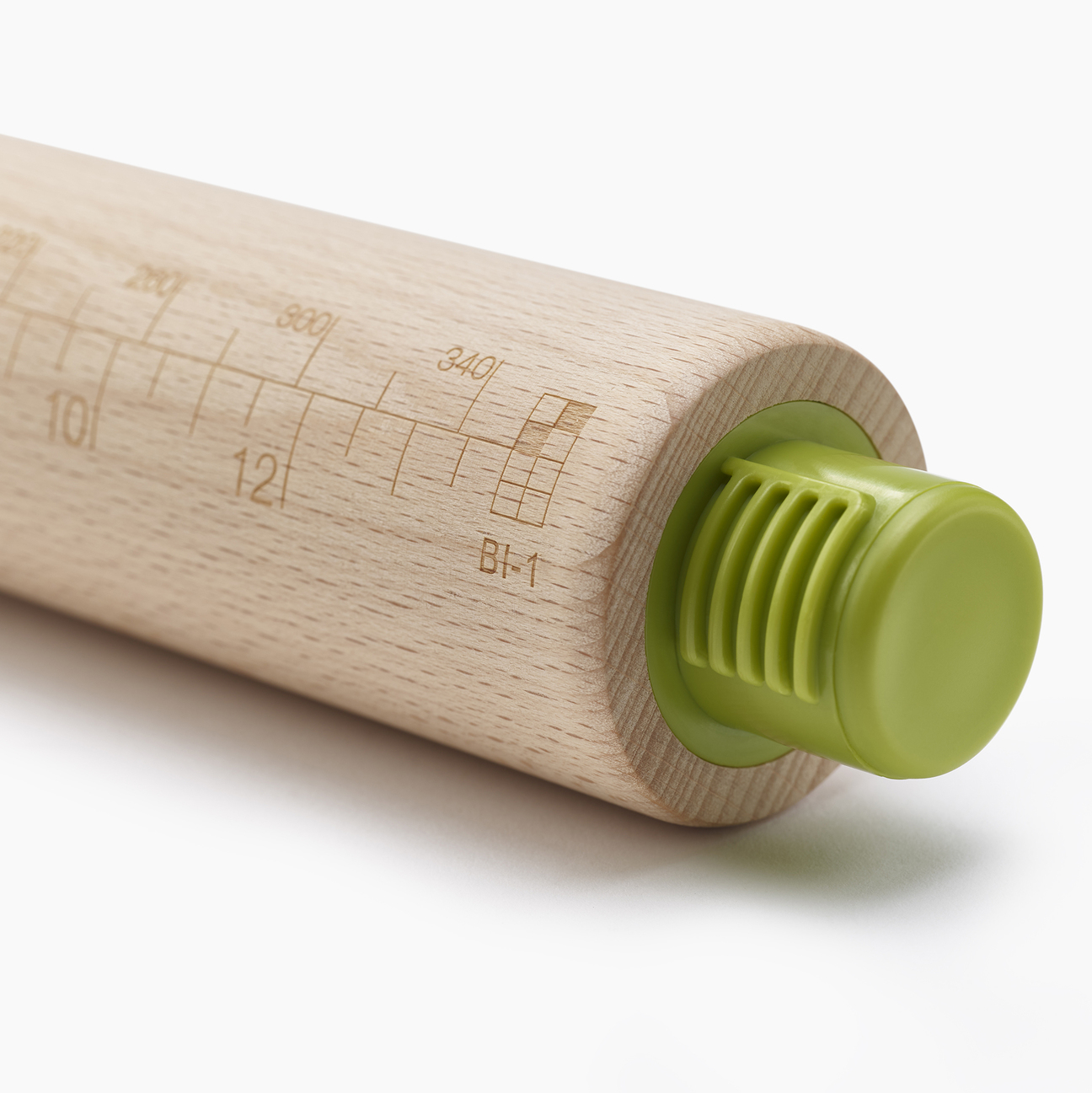 Primer plano de un rodillo de madera con extremos de plástico verde. Tiene marcas de medición y un logotipo en la madera.