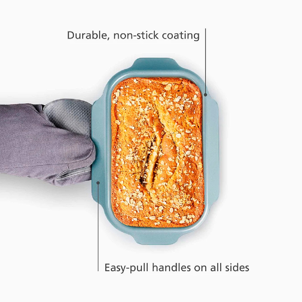 Ein gebackener Kuchen mit Nüssen in einer blauen Backform, gehalten von einem grauen Ofenhandschuh. Weißer Hintergrund. Text: Langlebige Antihaftbeschichtung.