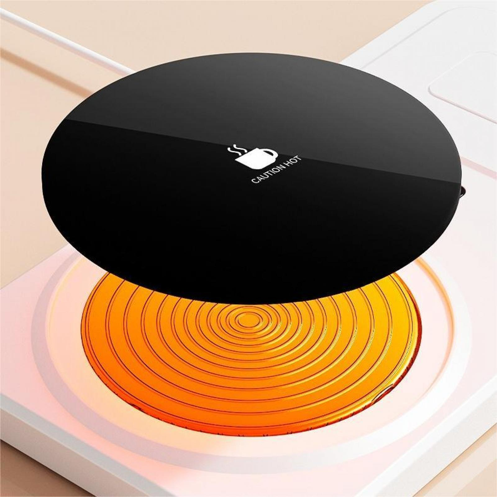 Eine schwarze, kreisförmige Kochplatte mit einem weißen Tassen-Symbol und dem Text 'VORSICHT HEISS'. Es steht auf einem weißen Sockel mit orangefarbenen Kreisen.