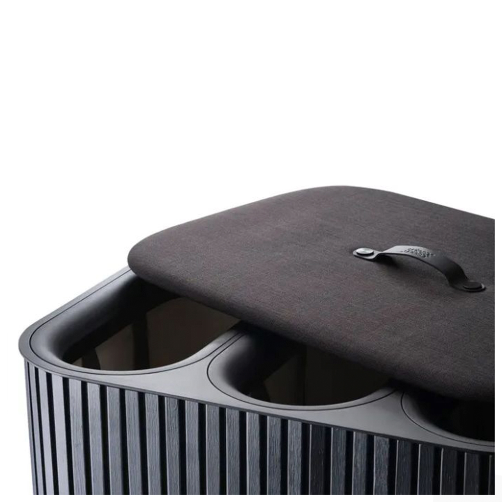 Un contenedor de almacenamiento gris oscuro con tres compartimentos. Tiene una tapa con asa y está parcialmente abierto. El contenedor es acanalado.