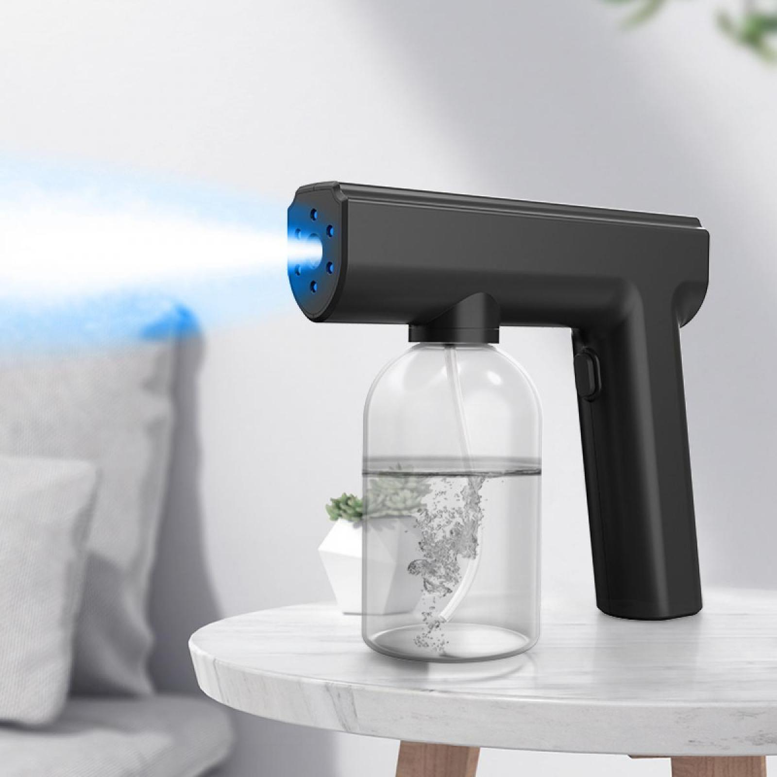 Schwarzes Desinfektionssprühgerät mit blauem Licht, Wasserflasche, auf einem Marmortisch.