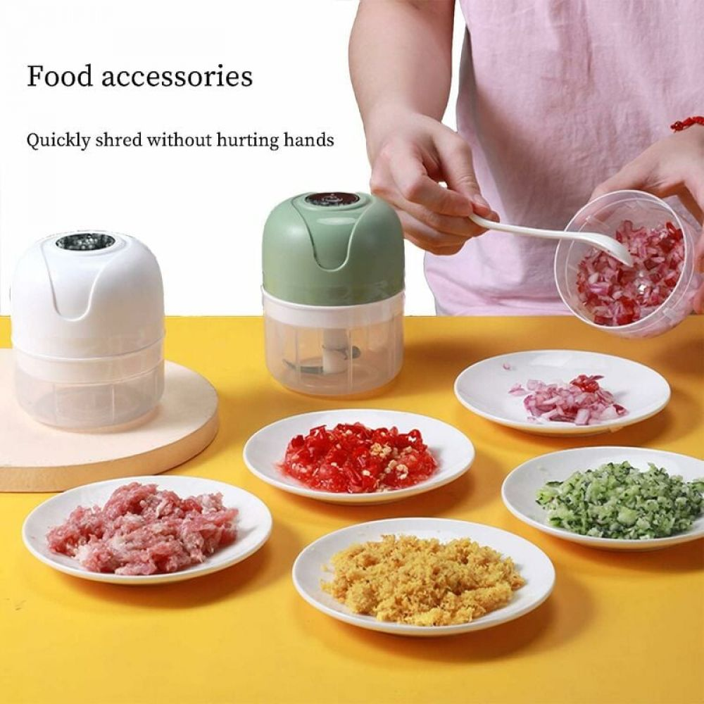 Ein Foodprozessor mit gehackten Zutaten auf Tellern. Eine Person verwendet einen Löffel, um Essen aus einem Behälter zu nehmen.