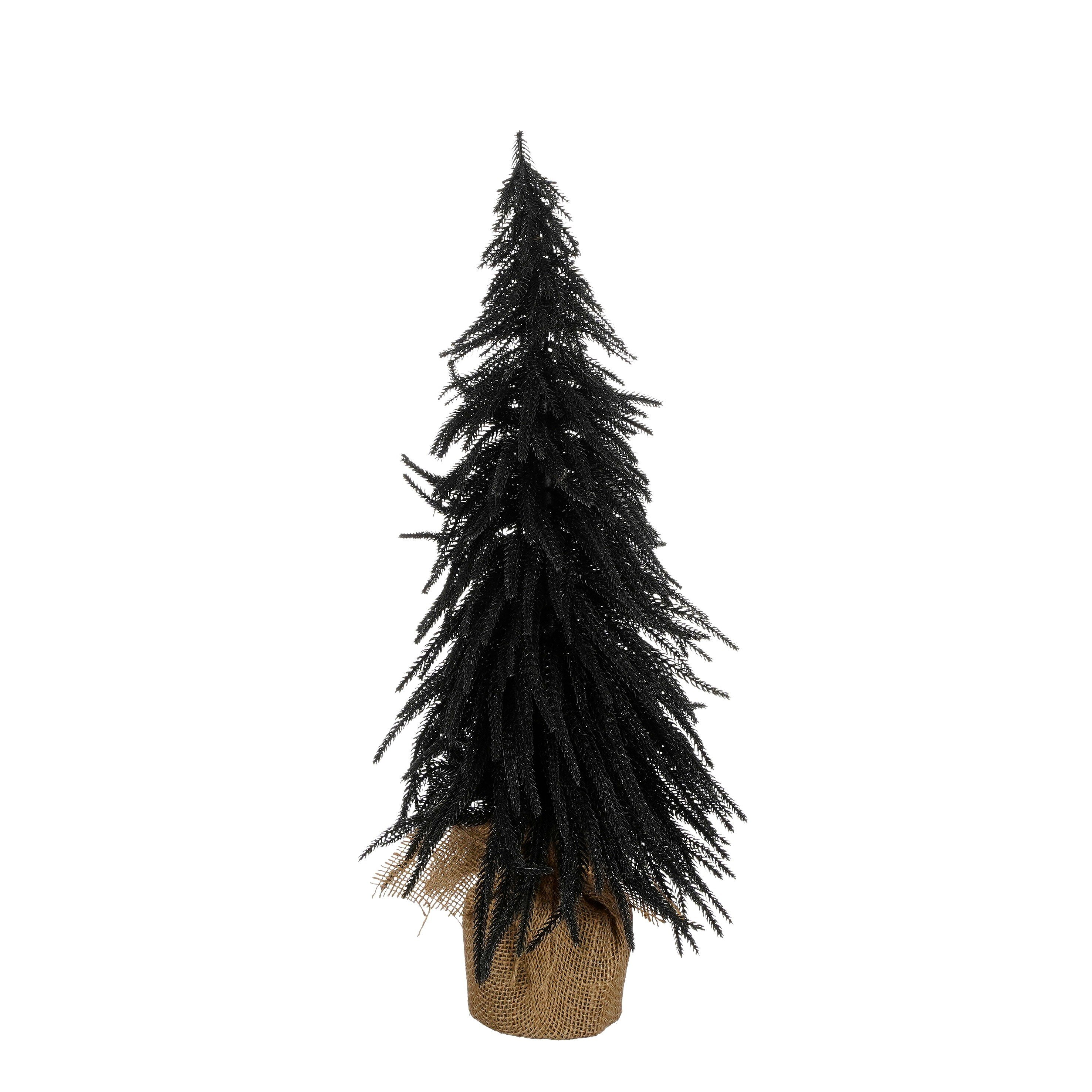 Un petit sapin de Noël artificiel noir sur fond blanc. La base est enveloppée de toile de jute.