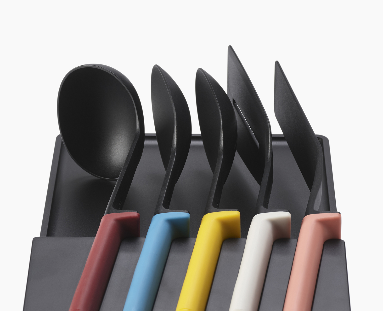 Un juego de utensilios de cocina negros en un soporte, con mangos coloridos. Cucharón, espátulas y cucharas de servir.