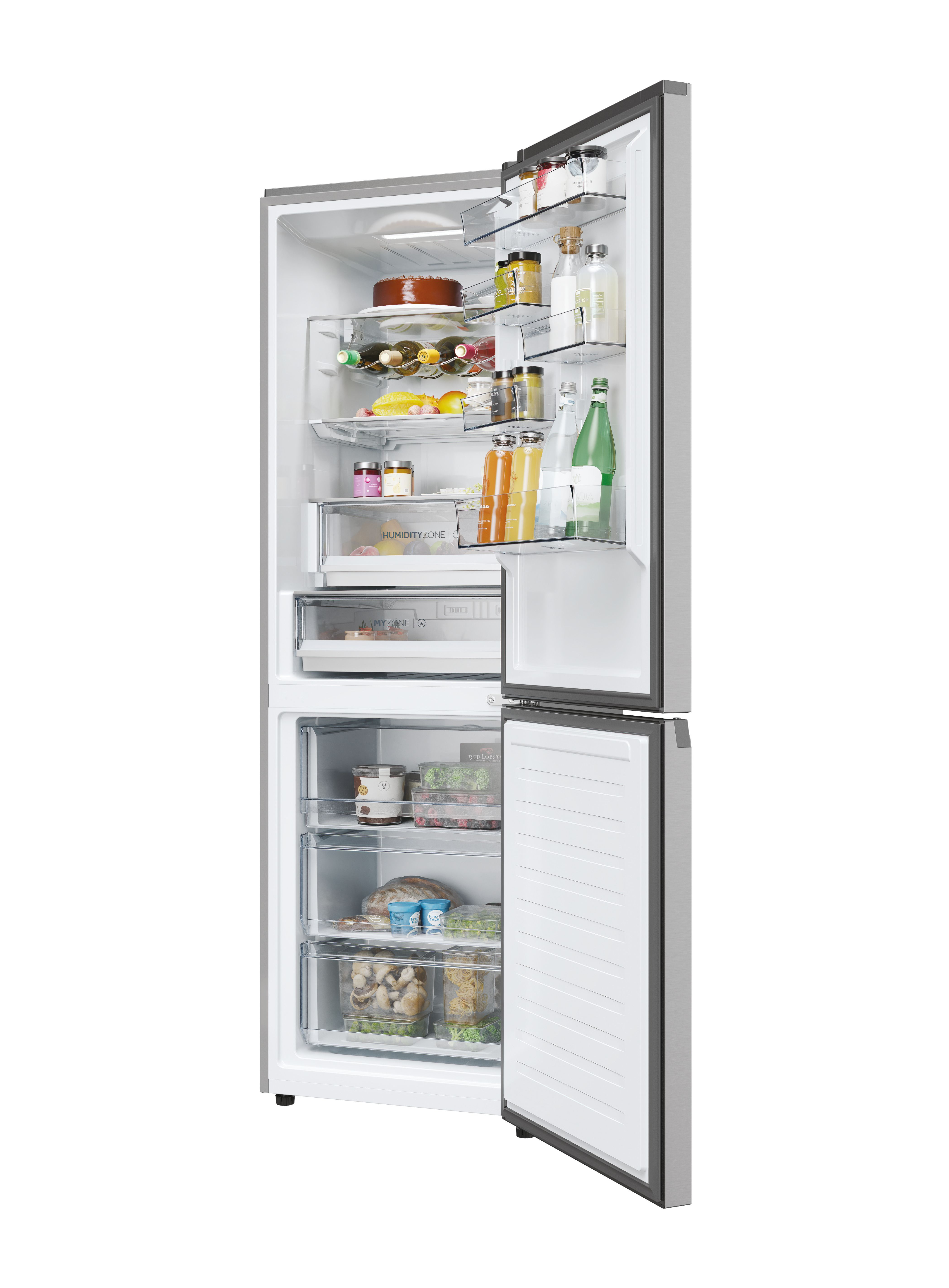 Otwarta lodówka wypełniona jedzeniem: ciasto, butelki, słoiki i pojemniki. Drzwi zamrażarki są również otwarte.