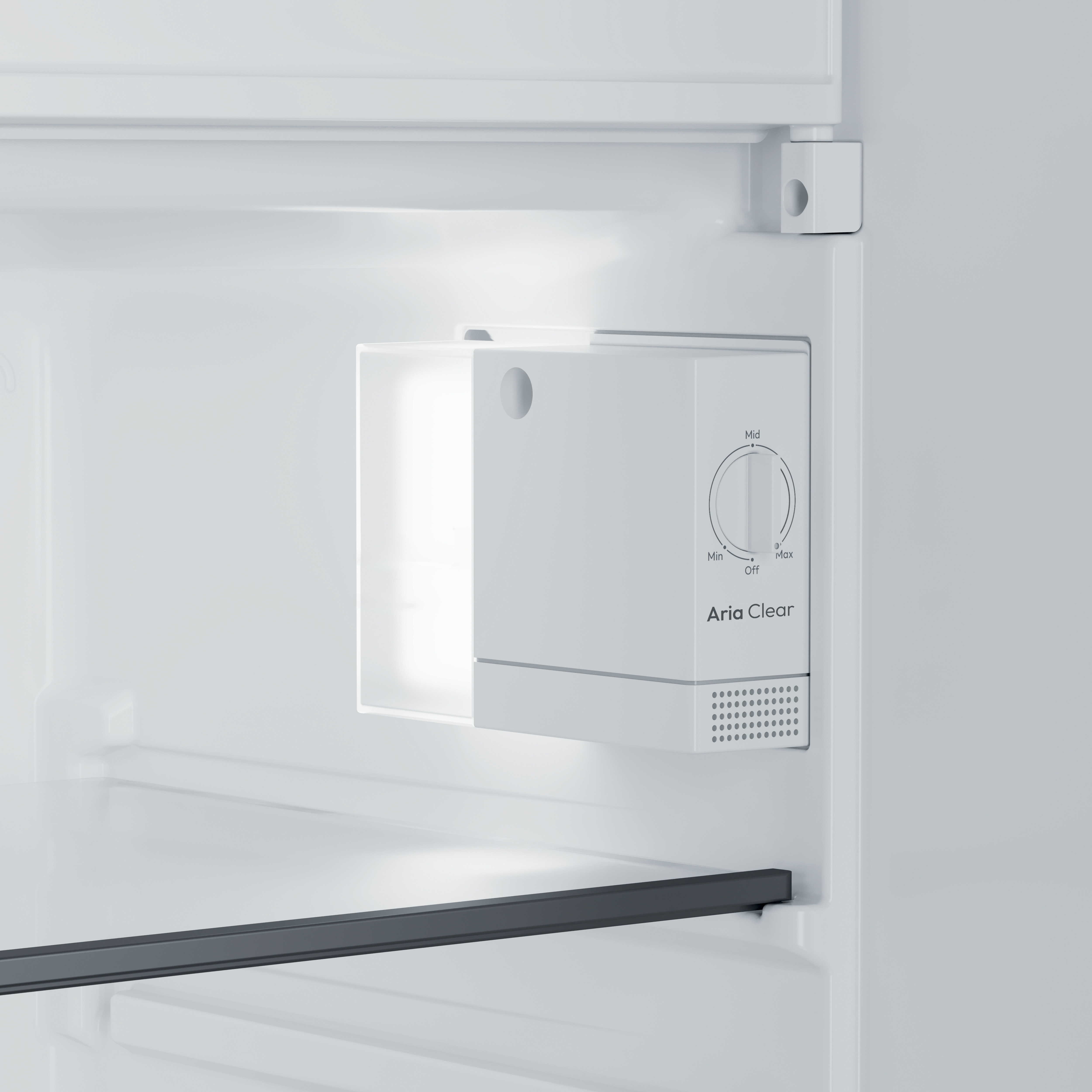 Wnętrze białej lodówki. Biała jednostka z pokrętłem Aria Clear. Ciemnoszara półka widoczna na dole.