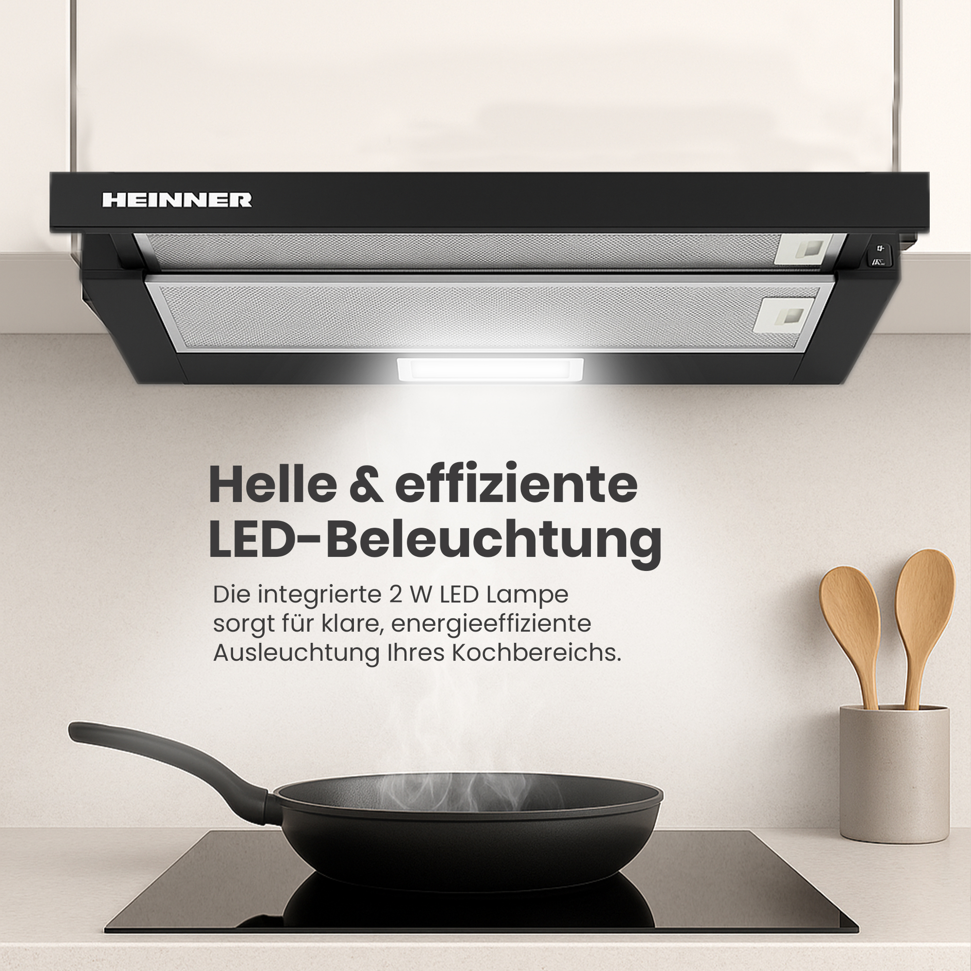 Une scène de cuisine avec une hotte noire, une poêle noire sur une plaque de cuisson et des ustensiles en bois.