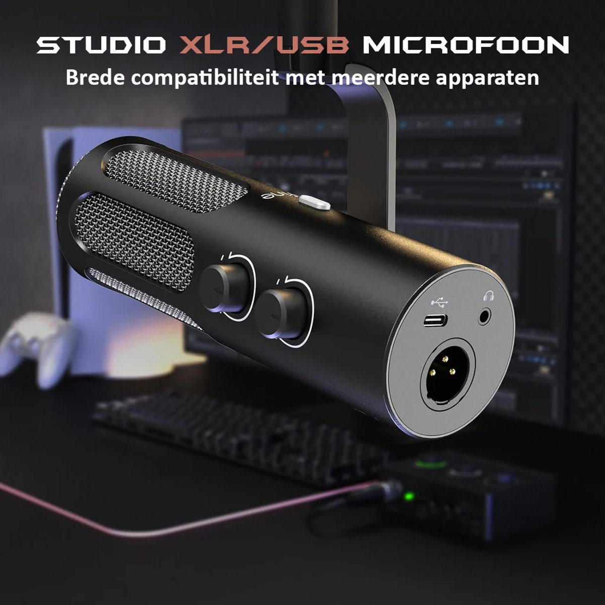 Een zwarte XLR/USB-microfoon hangt. Het heeft knoppen, een mesh-hoes en poorten. Een computer en toetsenbord staan op de achtergrond.