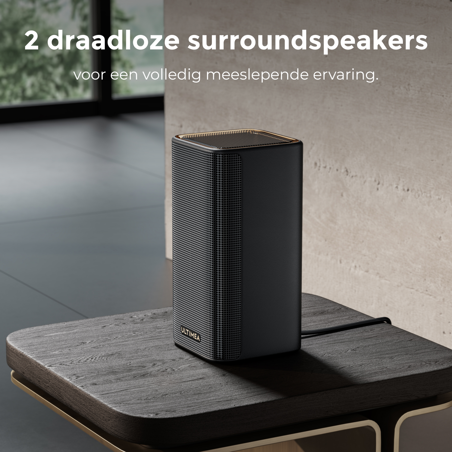 Un haut-parleur noir avec des accents dorés sur une table en bois sombre. Le texte dit : '2 draadloze surrounds speakers'.