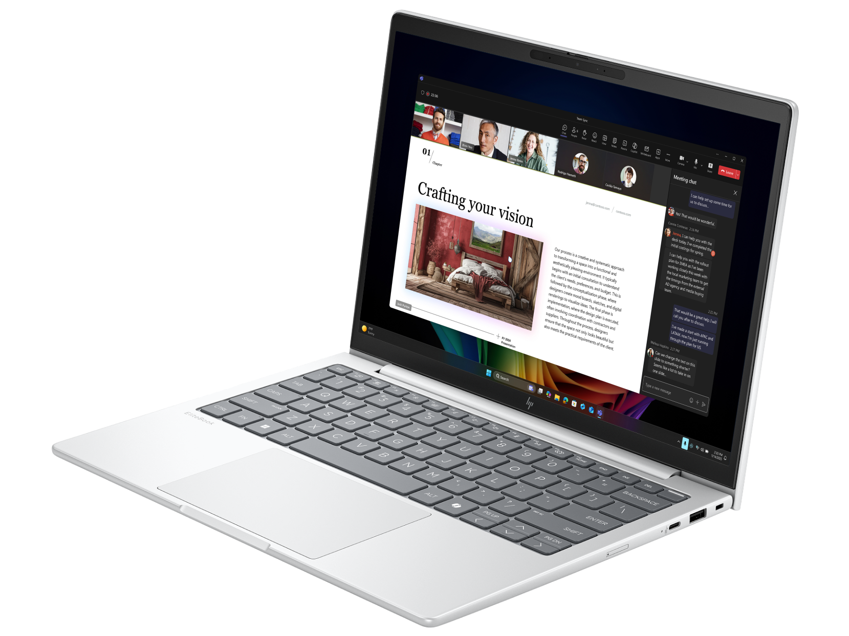 Un laptop argentato mostra una presentazione in una chiamata Teams, con tastiera e schermo visibili, su una superficie nera.