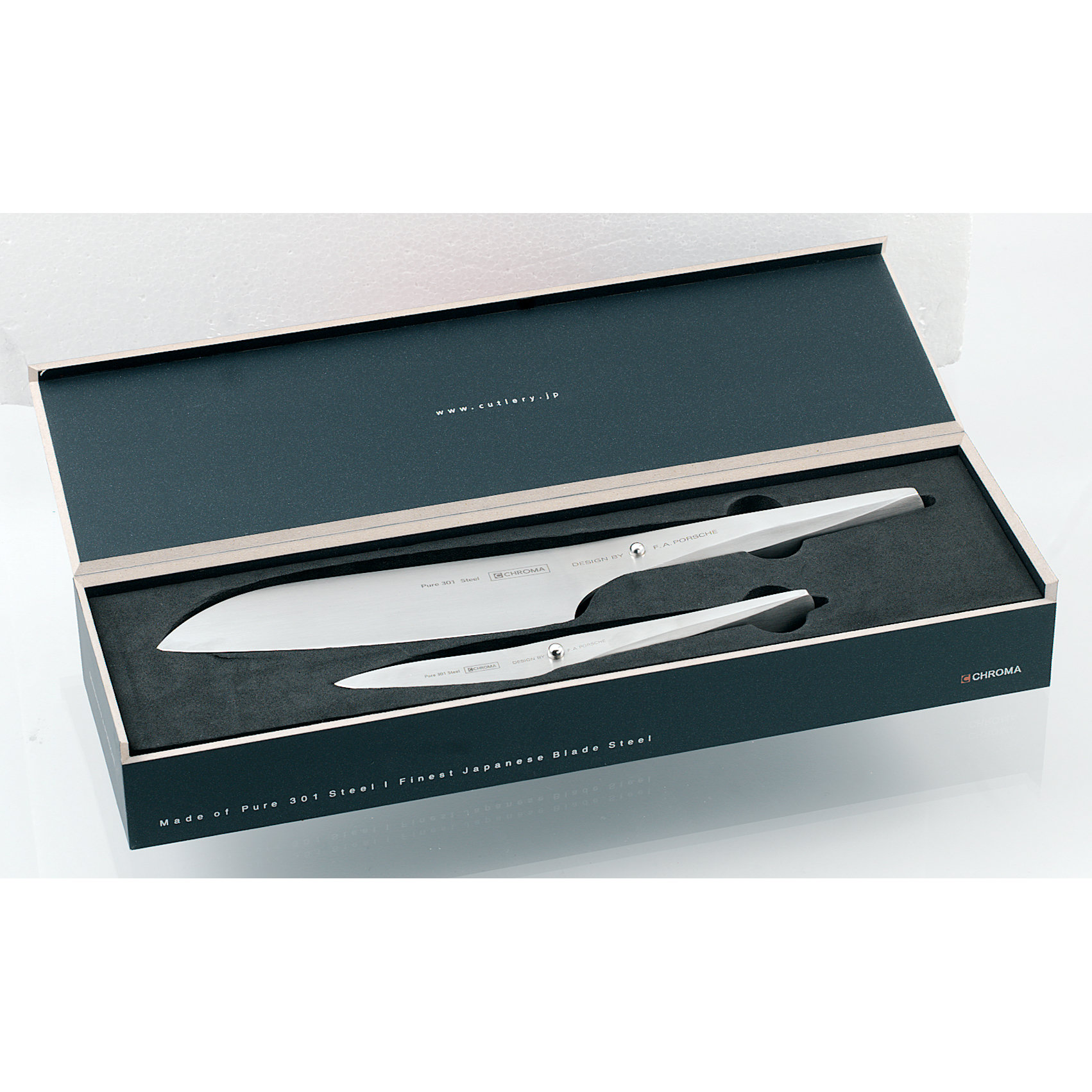 Ein Messerset in einer Schachtel. Das Set enthält zwei silberne Messer, ein großes Kochmesser und ein kleineres.