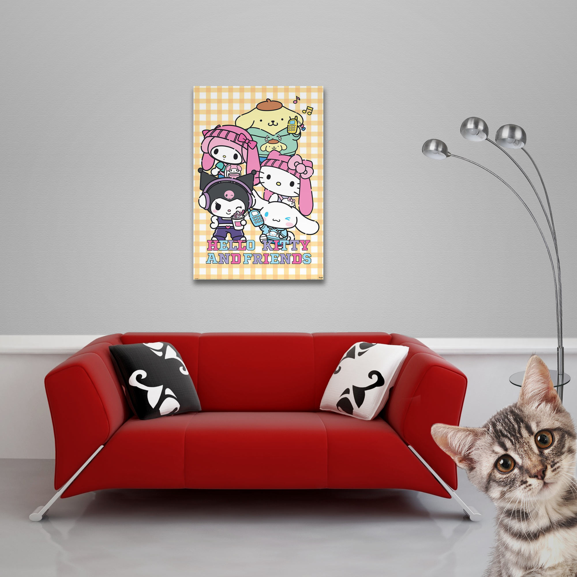 Rotes Sofa mit Kissen und einem Hello Kitty-Poster. Eine Katze ist im Vordergrund. Eine Lampe befindet sich rechts.