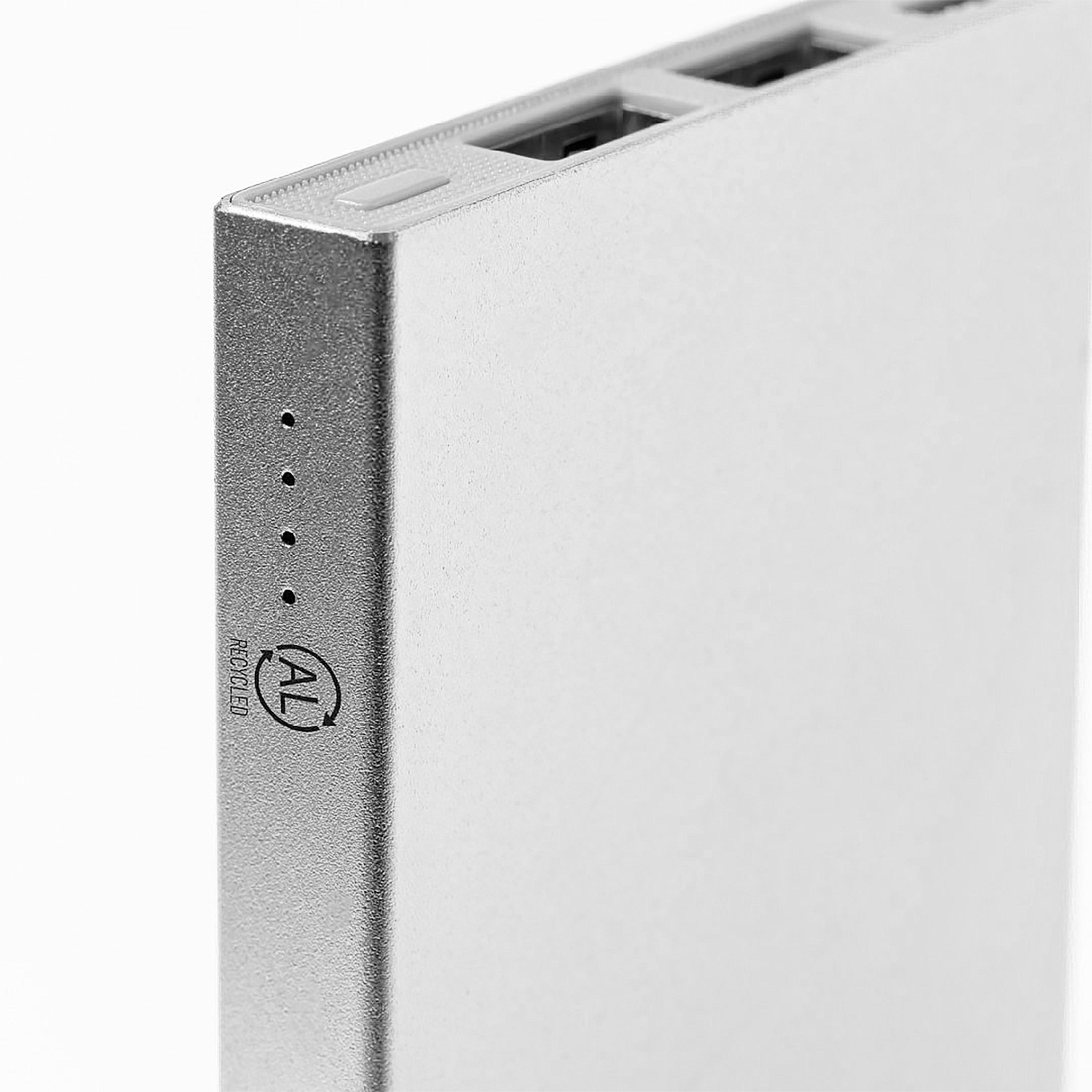 Un power bank argentato. Ha delle porte in alto e un logo di riciclo sul lato. La superficie è liscia e metallica.