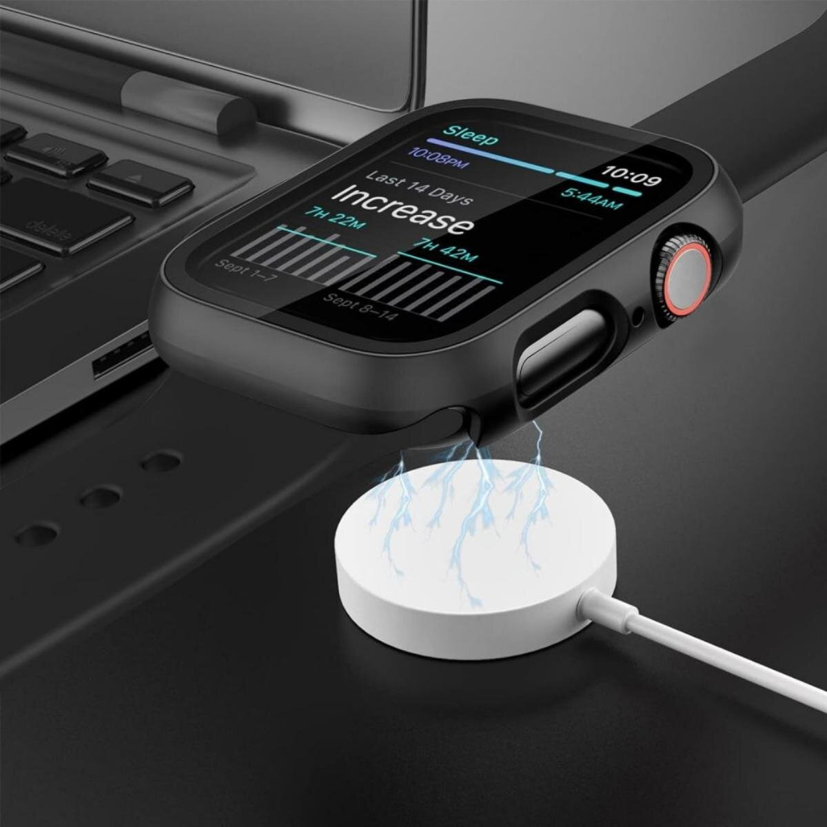 Une montre connectée noire se charge sur un socle blanc. La montre affiche les données de sommeil et l'heure. Un ordinateur portable est en arrière-plan.