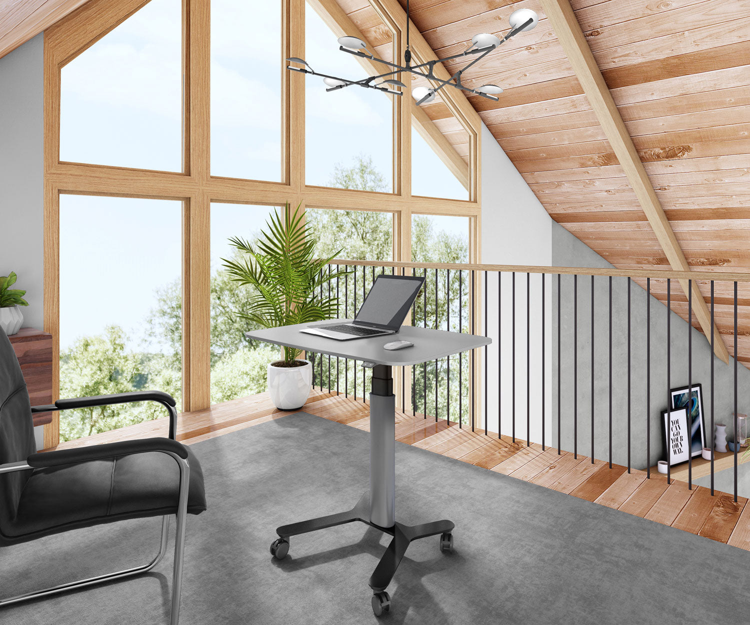 Ein Büro mit Laptop auf einem Stehpult, einem schwarzen Stuhl und großen Fenstern mit Blick auf Bäume. Holzdecke.