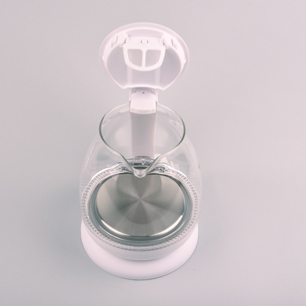 Un bollitore elettrico in vetro trasparente con base e coperchio bianchi, aperto. L'interno è in acciaio inox, sfondo grigio.