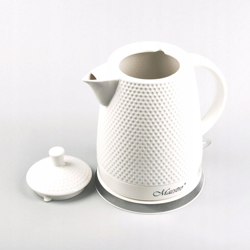 Biały czajnik elektryczny z teksturowanymi kropkami, bez pokrywy. Czajnik stoi na srebrnej podstawie z napisem 'Maestro'.