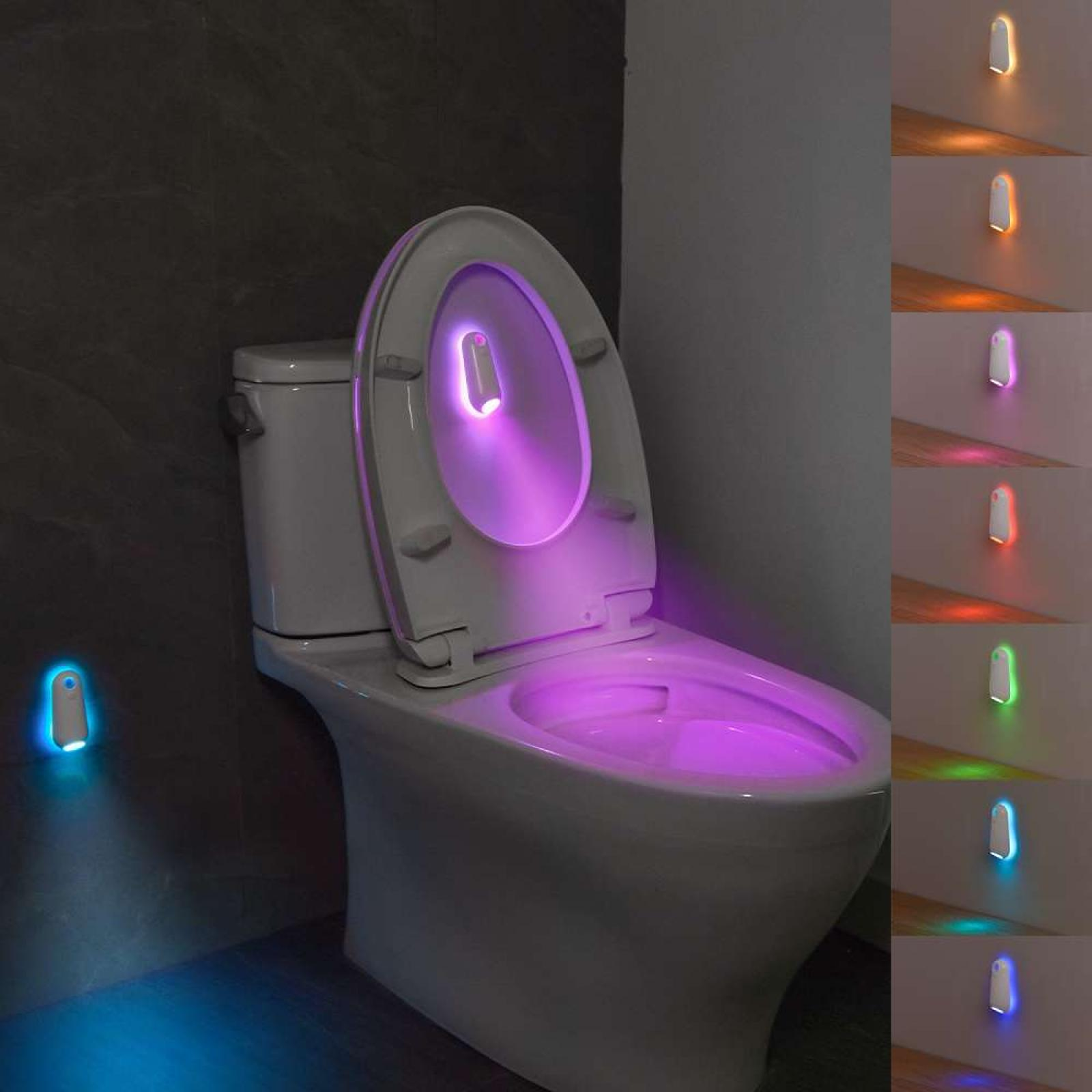 Eine Toilette mit einem violett leuchtenden Licht im Inneren. Verschiedenfarbige Lichter an der Wand.