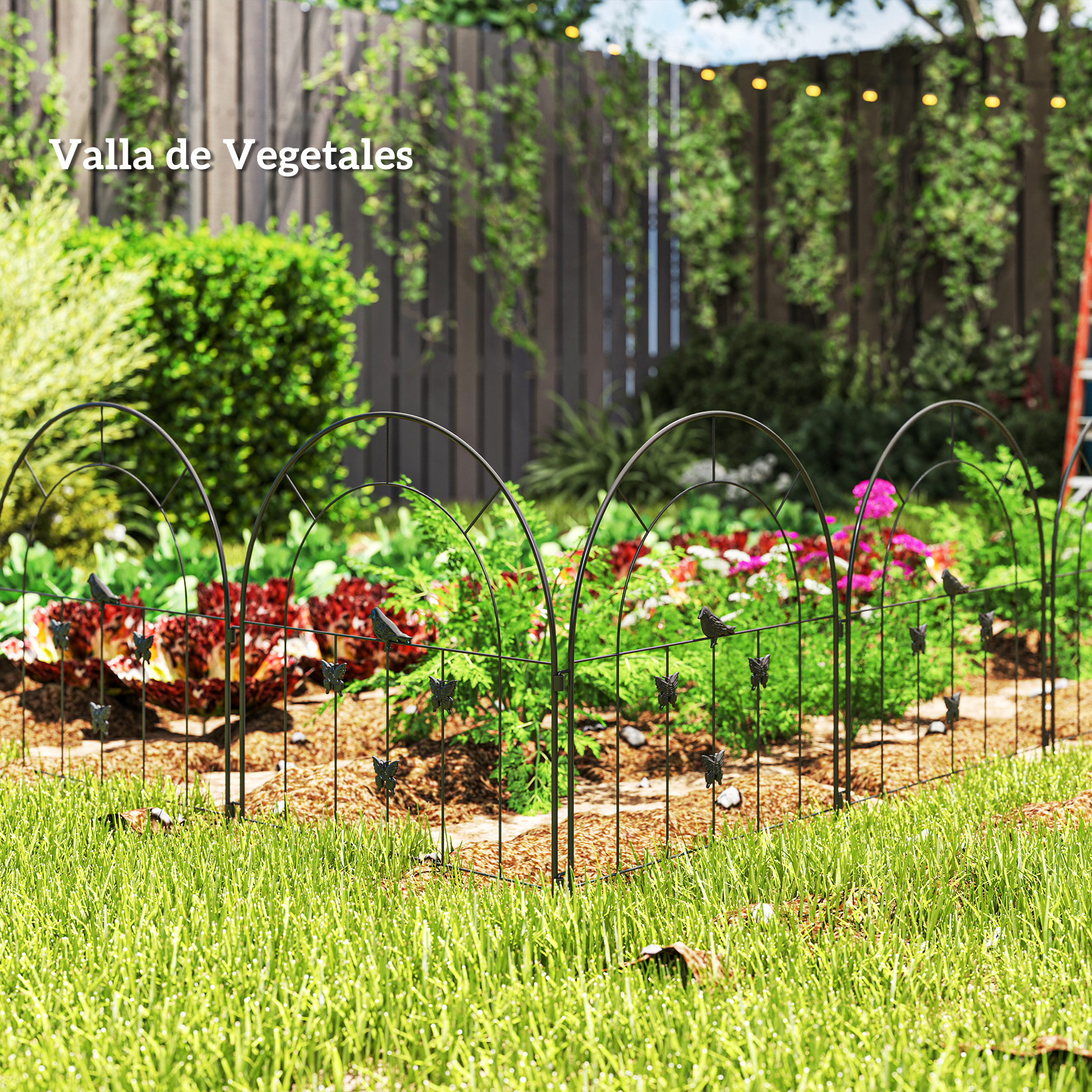Un jardín con una valla metálica negra decorada con pájaros y mariposas. Detrás, crecen verduras y flores.