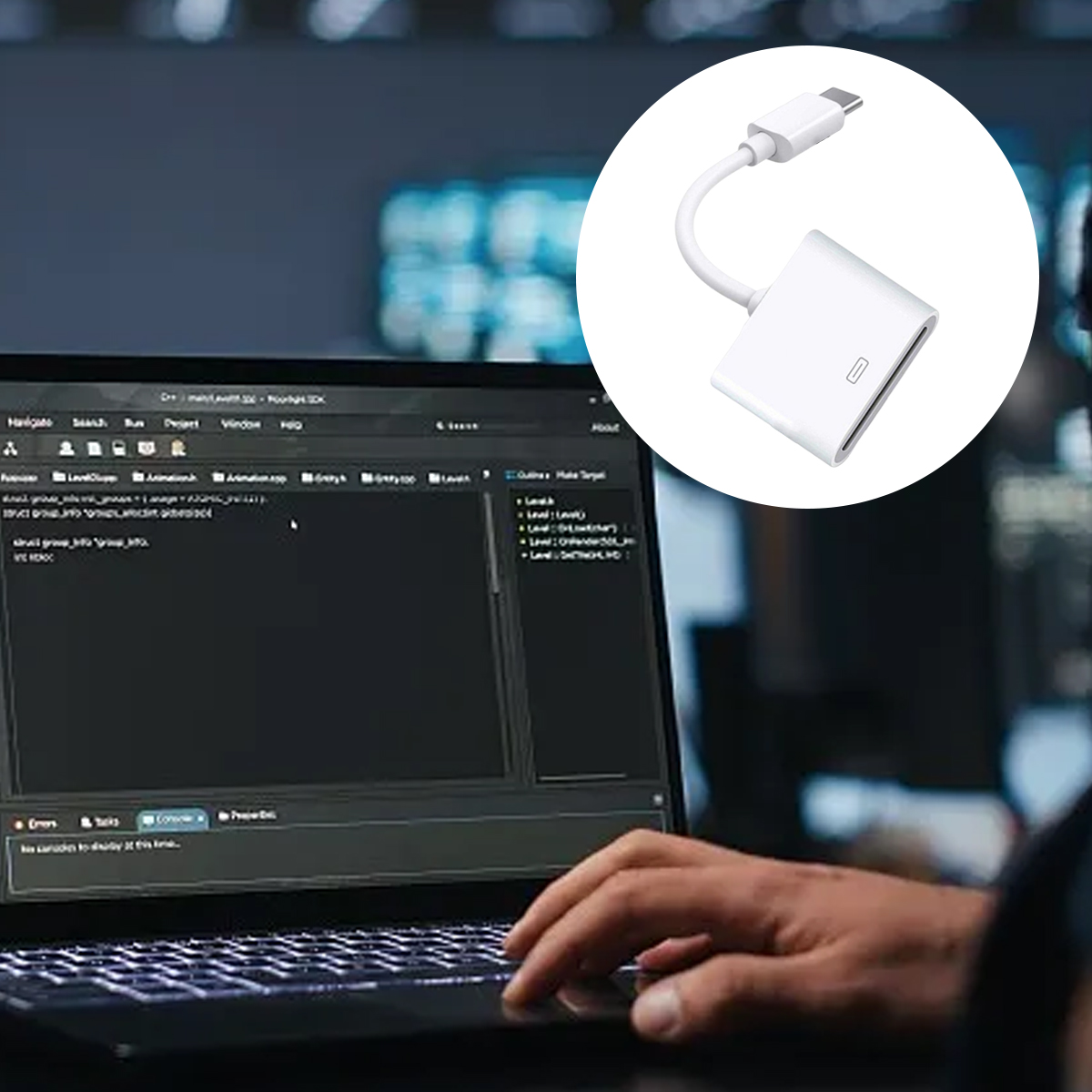 Eine Person benutzt einen Laptop, ein Adapter befindet sich im Kreis. Der Bildschirm zeigt Code. Der Hintergrund ist unscharf, mit dunklem Ton.