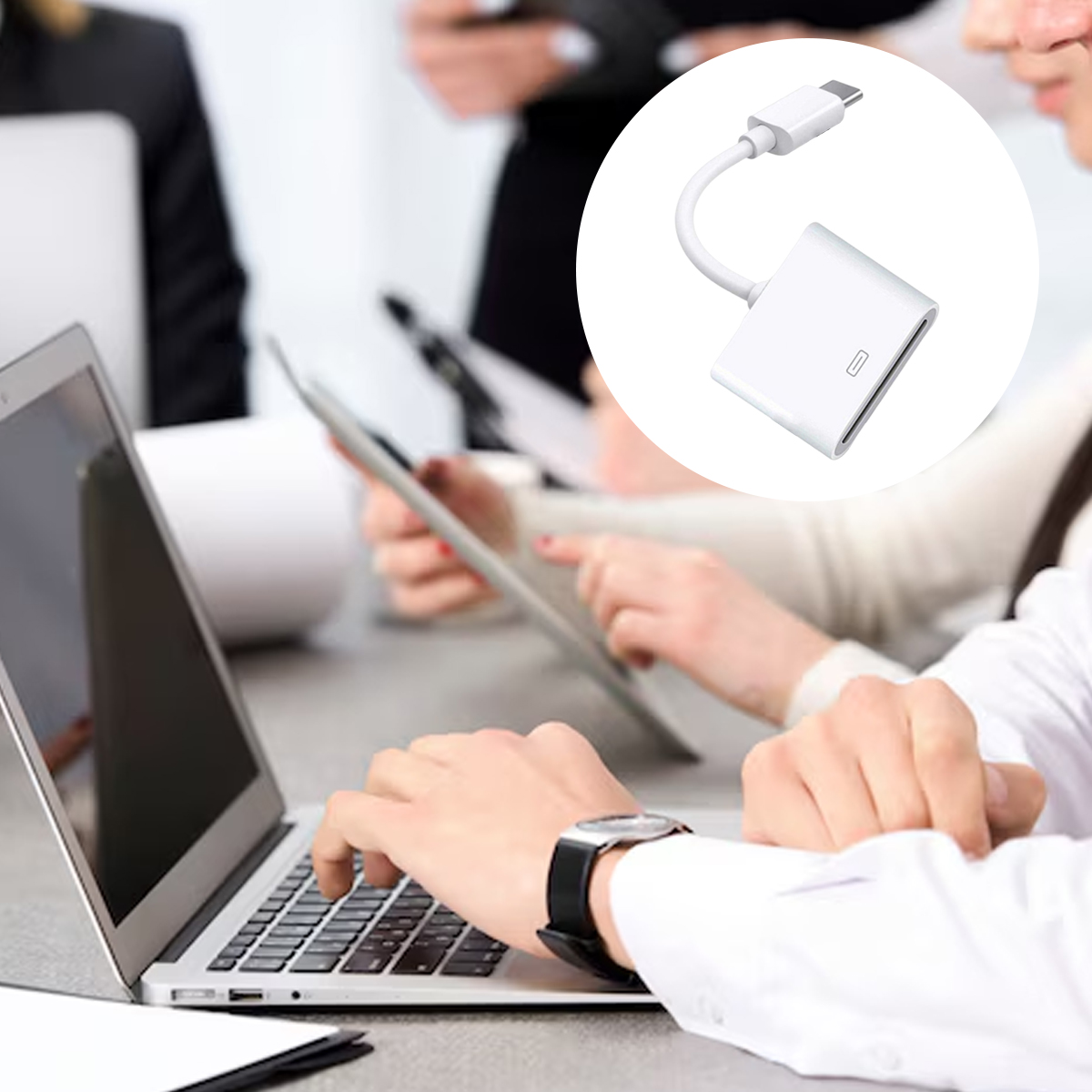Menschen arbeiten mit Laptops und Tablets. Ein weißer Adapter befindet sich in einem Kreis oben rechts.