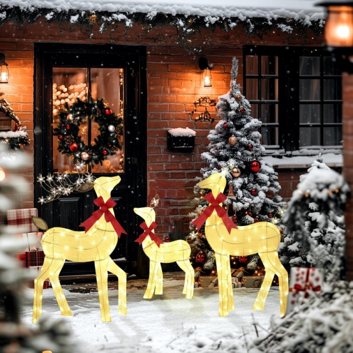 Eine verschneite Weihnachtsszene mit beleuchteten Rentierdekorationen, einem geschmückten Baum und einem Kranz an der Tür. Geschenke sind auf der Veranda platziert.