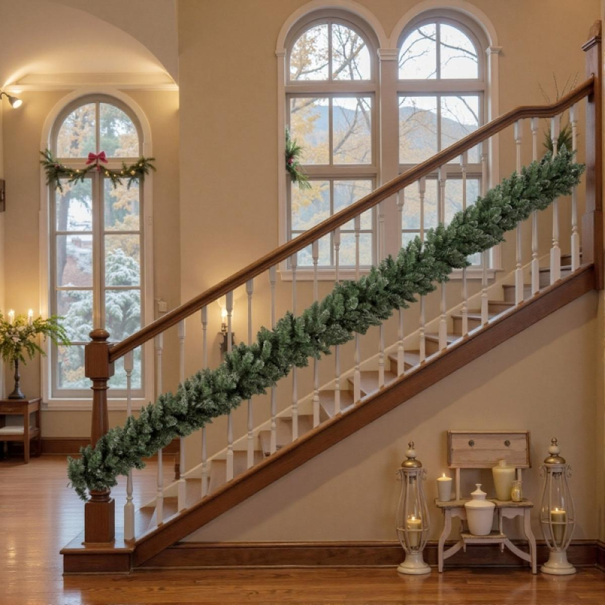 Eine Treppe mit einer grünen Girlande. Fenster im Hintergrund zeigen eine verschneite Landschaft. Kerzenlaternen und ein kleiner Tisch mit Kerzen.