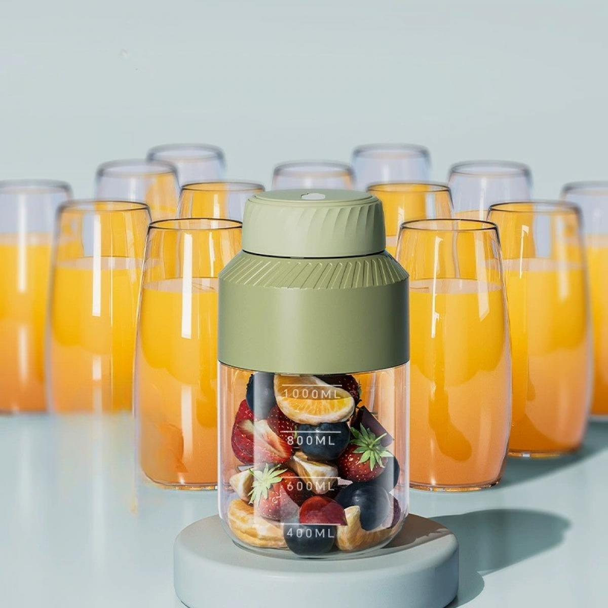 Ein Mixer mit Früchten steht auf einem Ständer, umgeben von Gläsern mit Orangensaft. Der Mixer ist grün und transparent.