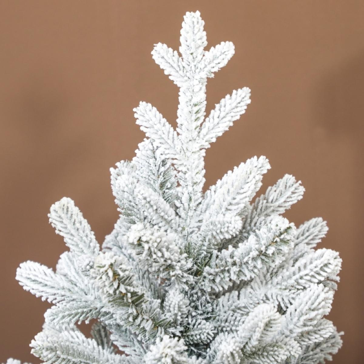 Nahaufnahme eines schneebedeckten Weihnachtsbaums. Der Baum ist grün mit weißem Schnee. Der Hintergrund ist ein brauner Farbverlauf.