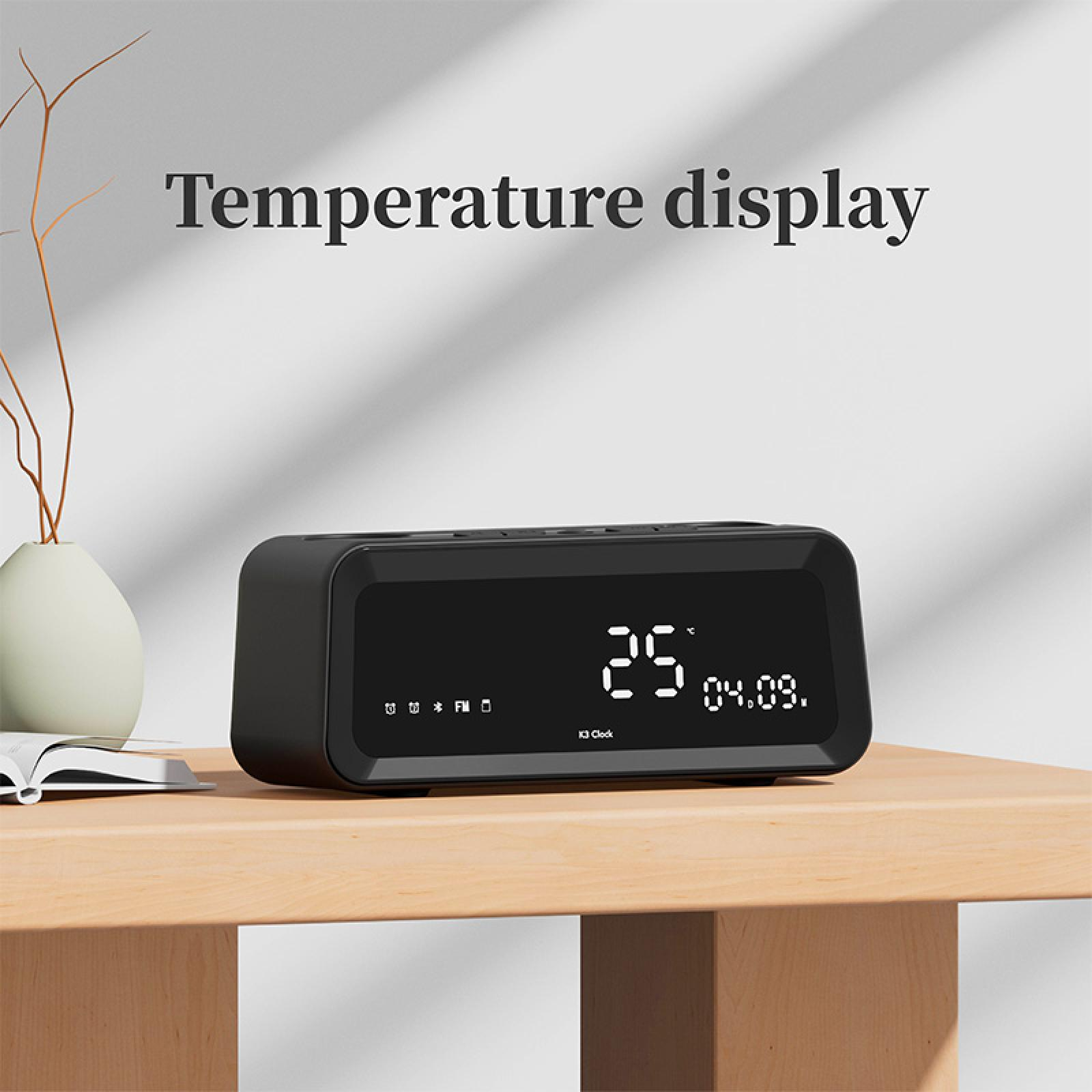 Schwarze Digitaluhr mit 25 Grad und Datum. Sie steht auf einem Holztisch. Text 'Temperature display' steht darüber.
