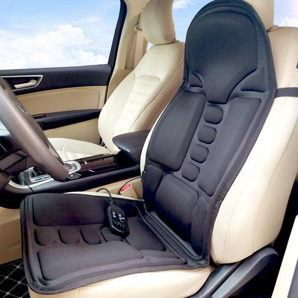 Schwarzer Autositz-Massagegerät auf einem beigen Autositz installiert. Eine Fernbedienung befindet sich auf dem Sitz. Der Himmel ist durch das Fenster sichtbar.