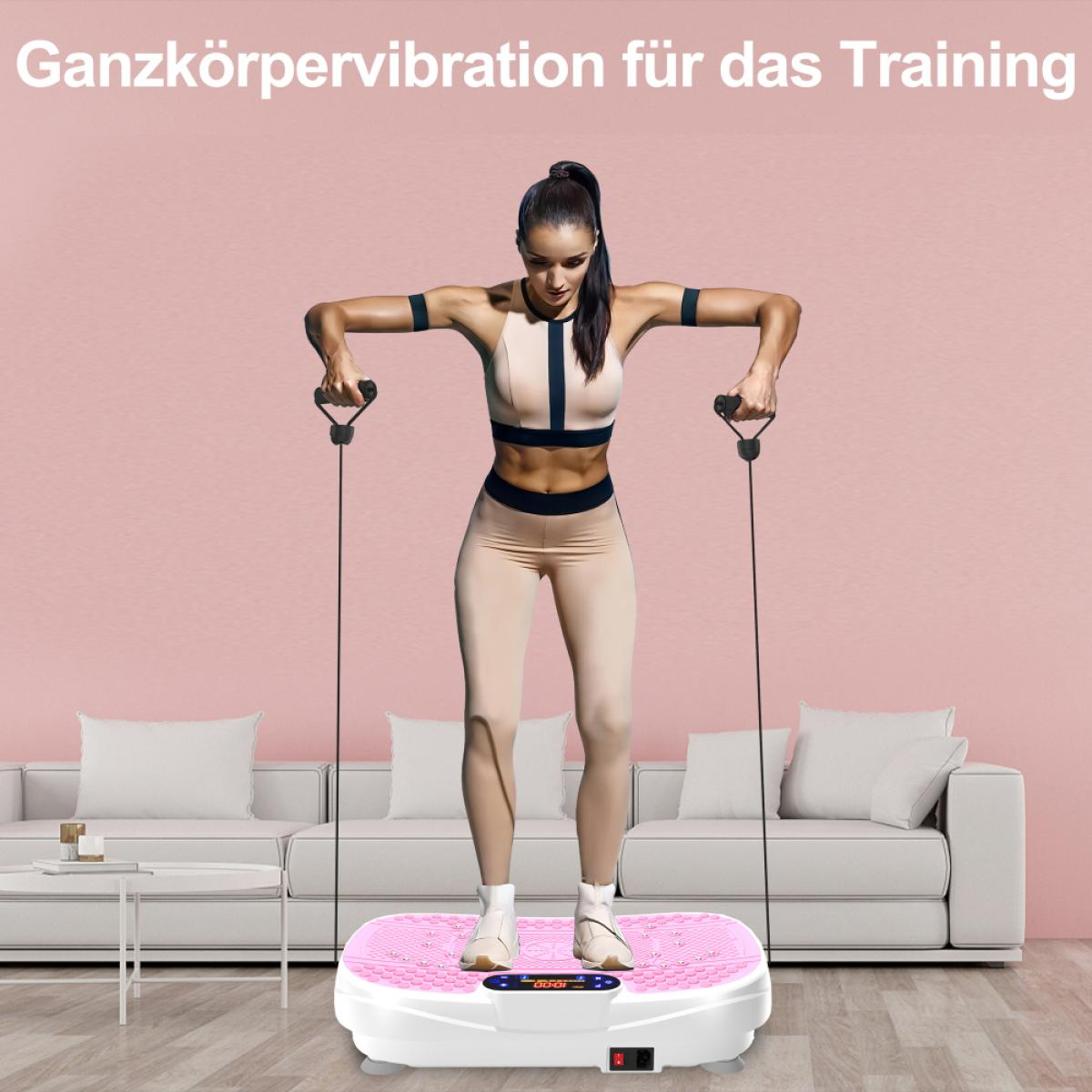 Frau trainiert auf einer rosa Vibrationsplatte und hält Griffe. Sie trägt beige Sportkleidung. Hintergrund: rosa Wand, weißes Sofa.