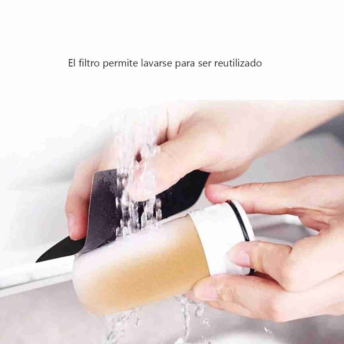 Manos lavando un filtro bajo agua corriente. El filtro es beige y blanco, con detalles negros.