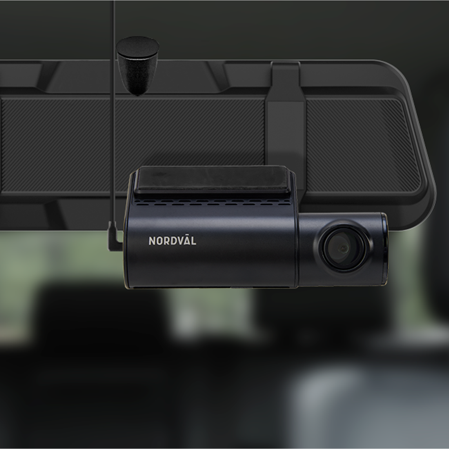 Une caméra de bord noire est fixée sur le rétroviseur d'une voiture. La caméra a un objectif et le mot NORDVÄL y est écrit.