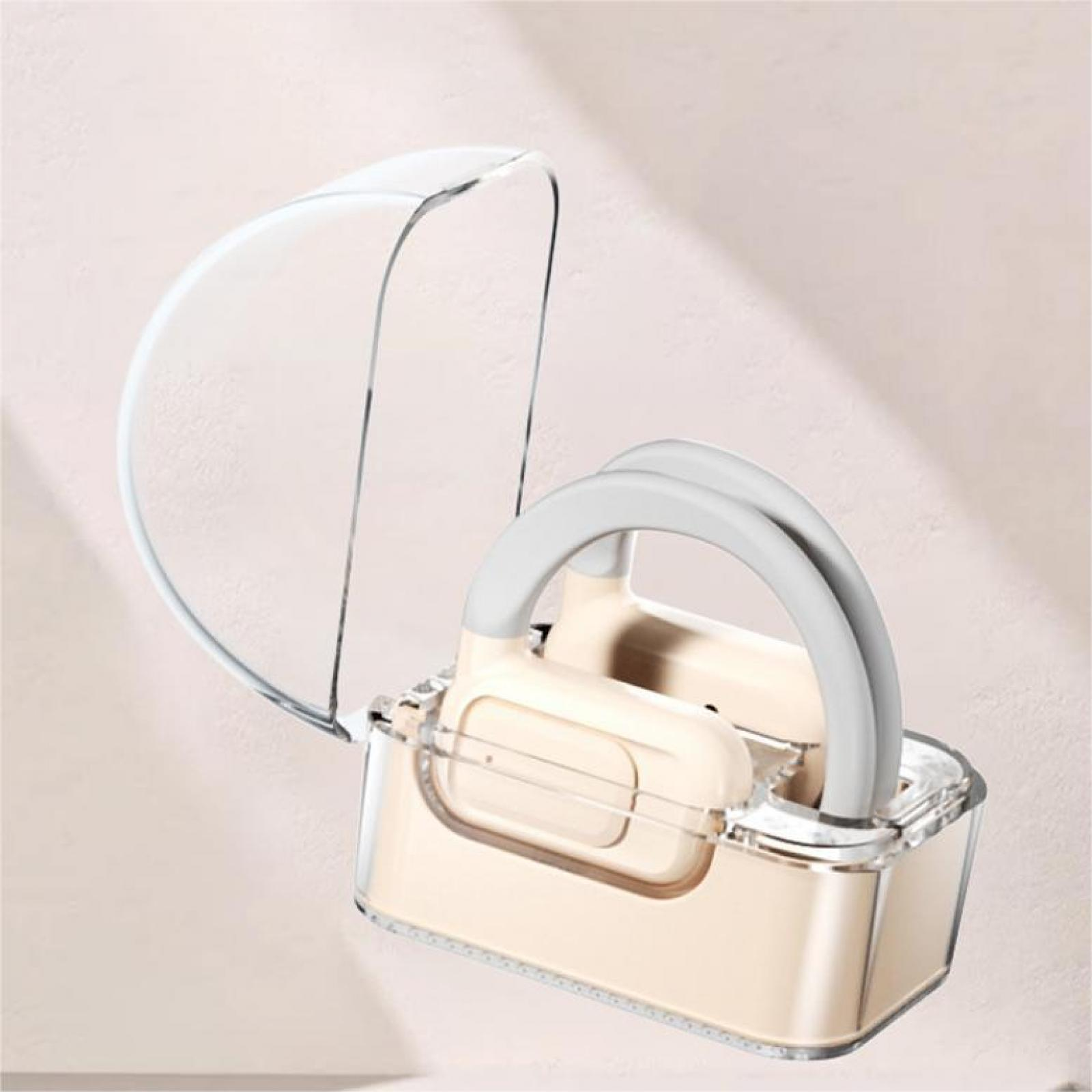 Ein durchsichtiger, teilweise offener Behälter mit cremefarbenem Innenraum und grauen Griffen, vor hellem rosa Hintergrund.
