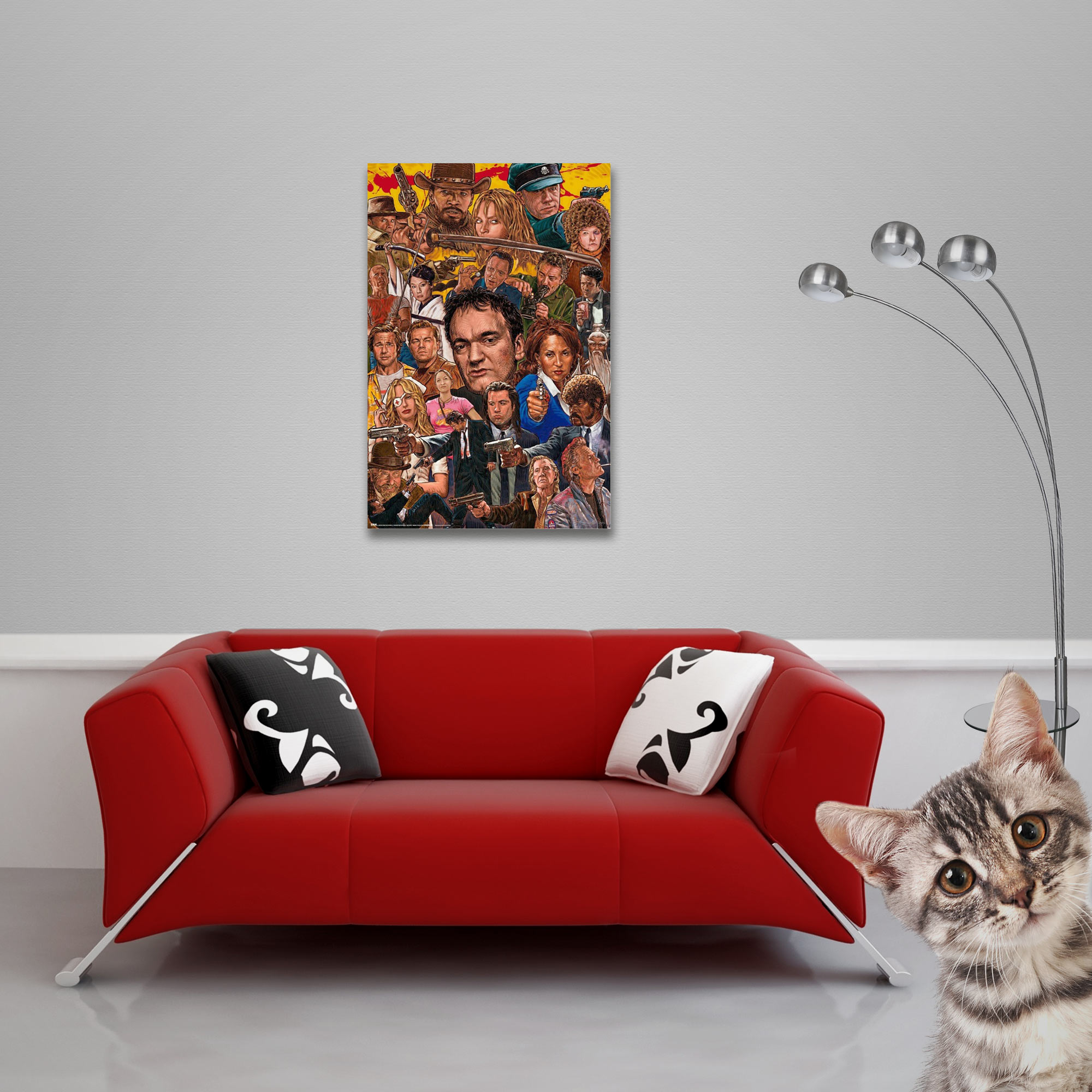 Rotes Sofa mit Kissen und Filmplakat an der Wand. Eine Katze im Vordergrund schaut in die Kamera.