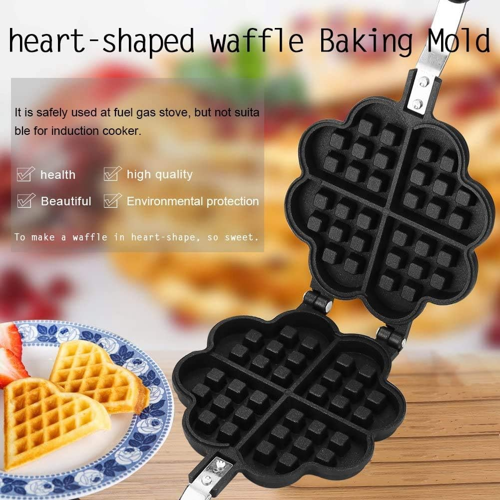 Ein herzförmiges Waffeleisen ist geöffnet und zeigt die Waffelform. Unten liegen Waffeln mit Obst auf einem Teller.
