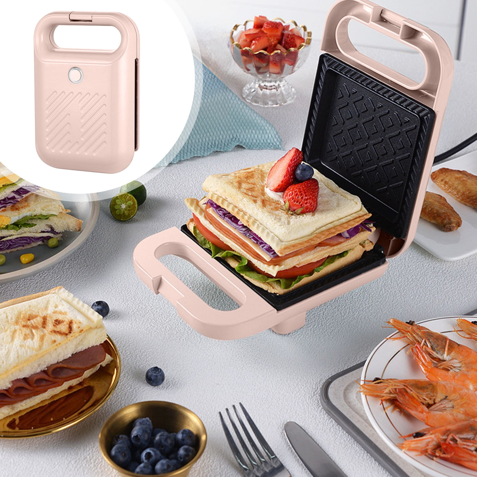 Ein rosa Sandwichmaker mit einem Sandwich darin, umgeben von anderen Lebensmitteln wie Erdbeeren, Garnelen und Sandwiches.