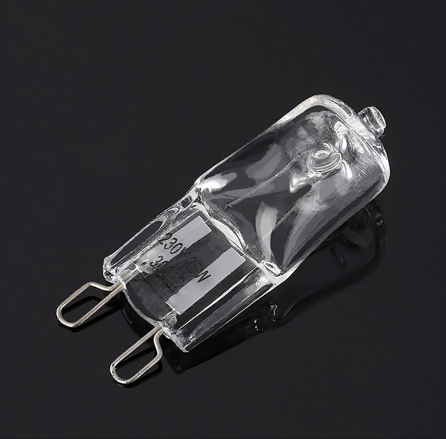 Eine klare Halogenlampe mit Metallzinken, die auf einer reflektierenden schwarzen Oberfläche liegt.